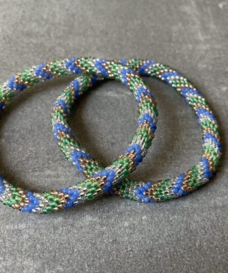 Nepal armbånd er en inspirerende og fascinerende smykkegenre, der vækker interessen hos smykkeentusiaster over hele verden. Disse håndlavede armbånd er kunstværker, der udstråler autenticitet, skønhed og dyb symbolik. Lad os dykke ned i den betagende verden af Nepal armbånd og udforske, hvad der gør dem så unikke og eftertragtede. Hvert Nepal armbånd er unikt, og det er netop denne individualitet, der appellerer til mange. Armbåndene er ofte skabt af dygtige nepalesiske håndværkere, der gennem generationer har forfinet deres teknikker til at skabe smykker af høj kvalitet. Disse håndværkere bruger traditionelle metoder, som har været en del af Nepals kultur og historie i århundreder. Processen er omhyggelig og kræver en stor grad af præcision og tålmodighed, hvilket gør hvert armbånd til en kærlighedsfyldt skabelse. Nepal armbånd er kendt for deres farverige og levende design. De er ofte dekoreret med perler, ædelstene, træ, metal eller andre naturlige materialer, hvilket giver dem et unikt udseende. Hvert enkelt element, der anvendes i armbåndene, er udvalgt omhyggeligt for at skabe en harmonisk kombination af farver og teksturer. Disse elementer er ofte inspireret af Nepals rige natur og kultur, hvilket giver armbåndene en autentisk følelse og en stærk forbindelse til landet. Symbolik spiller også en vigtig rolle i Nepal armbåndenes popularitet. Mange af armbåndene har indgraverede mønstre eller symboler, der repræsenterer vigtige aspekter af Nepals traditioner og spiritualitet. Disse symboler kan have betydning for held, lykke, kærlighed, beskyttelse eller en dybere forbindelse til naturen. At bære et Nepal armbånd kan derfor have en dybere betydning for bæreren og kan fungere som en påmindelse om deres forbindelse til Nepals rige arv. Nepal armbånd er ikke kun smukke smykker, men de har også en stærk social og kulturel betydning. Mange af disse smykker er håndlavede af kvinder, der er en del af samfundet i landområderne i Nepal. Produktionen af armbåndene giver disse kvinder mulighed for at skabe en bæredygtig indkomst, forbedre deres levevilkår og styrke deres selvstændighed. Når du køber et Nepal armbånd, bidrager du derfor til at støtte en positiv social indvirkning og bevare traditionelle håndværksmæssige metoder. Udover deres kulturelle og sociale betydning er Nepal armbånd også en favorit blandt modebevidste enkeltpersoner, der ønsker at tilføje en unik og autentisk touch til deres stil. Disse armbånd kan styles på utallige måder, uanset om du ønsker at skabe et bohemeinspireret look, en farverig festlig stil eller en subtil og elegant kombination. Der er et Nepal armbånd til enhver lejlighed og enhver personlig præference. I det store udvalg af smykker, der findes i dagens marked, skiller Nepal armbånd sig ud som en særlig perle. Deres håndlavede karakter, farverige design, dybe symbolik og sociale indvirkning gør dem til mere end bare smykker - de er en form for kunst og kultur, der fortæller historien om Nepal og dets folk. Ved at bære et Nepal armbånd, bærer du også med dig en del af dette rige og inspirerende land. Så uanset om du leder efter en meningsfuld gave eller ønsker at berige din egen smykkesamling, vil et Nepal armbånd være et mindeværdigt og værdsat valg.