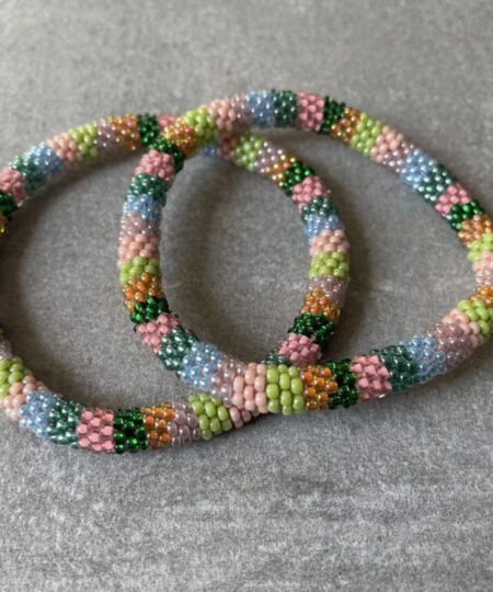 Nepal armbånd er en inspirerende og fascinerende smykkegenre, der vækker interessen hos smykkeentusiaster over hele verden. Disse håndlavede armbånd er kunstværker, der udstråler autenticitet, skønhed og dyb symbolik. Lad os dykke ned i den betagende verden af Nepal armbånd og udforske, hvad der gør dem så unikke og eftertragtede. Hvert Nepal armbånd er unikt, og det er netop denne individualitet, der appellerer til mange. Armbåndene er ofte skabt af dygtige nepalesiske håndværkere, der gennem generationer har forfinet deres teknikker til at skabe smykker af høj kvalitet. Disse håndværkere bruger traditionelle metoder, som har været en del af Nepals kultur og historie i århundreder. Processen er omhyggelig og kræver en stor grad af præcision og tålmodighed, hvilket gør hvert armbånd til en kærlighedsfyldt skabelse. Nepal armbånd er kendt for deres farverige og levende design. De er ofte dekoreret med perler, ædelstene, træ, metal eller andre naturlige materialer, hvilket giver dem et unikt udseende. Hvert enkelt element, der anvendes i armbåndene, er udvalgt omhyggeligt for at skabe en harmonisk kombination af farver og teksturer. Disse elementer er ofte inspireret af Nepals rige natur og kultur, hvilket giver armbåndene en autentisk følelse og en stærk forbindelse til landet. Symbolik spiller også en vigtig rolle i Nepal armbåndenes popularitet. Mange af armbåndene har indgraverede mønstre eller symboler, der repræsenterer vigtige aspekter af Nepals traditioner og spiritualitet. Disse symboler kan have betydning for held, lykke, kærlighed, beskyttelse eller en dybere forbindelse til naturen. At bære et Nepal armbånd kan derfor have en dybere betydning for bæreren og kan fungere som en påmindelse om deres forbindelse til Nepals rige arv. Nepal armbånd er ikke kun smukke smykker, men de har også en stærk social og kulturel betydning. Mange af disse smykker er håndlavede af kvinder, der er en del af samfundet i landområderne i Nepal. Produktionen af armbåndene giver disse kvinder mulighed for at skabe en bæredygtig indkomst, forbedre deres levevilkår og styrke deres selvstændighed. Når du køber et Nepal armbånd, bidrager du derfor til at støtte en positiv social indvirkning og bevare traditionelle håndværksmæssige metoder. Udover deres kulturelle og sociale betydning er Nepal armbånd også en favorit blandt modebevidste enkeltpersoner, der ønsker at tilføje en unik og autentisk touch til deres stil. Disse armbånd kan styles på utallige måder, uanset om du ønsker at skabe et bohemeinspireret look, en farverig festlig stil eller en subtil og elegant kombination. Der er et Nepal armbånd til enhver lejlighed og enhver personlig præference. I det store udvalg af smykker, der findes i dagens marked, skiller Nepal armbånd sig ud som en særlig perle. Deres håndlavede karakter, farverige design, dybe symbolik og sociale indvirkning gør dem til mere end bare smykker - de er en form for kunst og kultur, der fortæller historien om Nepal og dets folk. Ved at bære et Nepal armbånd, bærer du også med dig en del af dette rige og inspirerende land. Så uanset om du leder efter en meningsfuld gave eller ønsker at berige din egen smykkesamling, vil et Nepal armbånd være et mindeværdigt og værdsat valg.