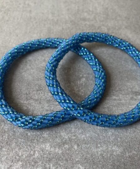 Nepal armbånd er en inspirerende og fascinerende smykkegenre, der vækker interessen hos smykkeentusiaster over hele verden. Disse håndlavede armbånd er kunstværker, der udstråler autenticitet, skønhed og dyb symbolik. Lad os dykke ned i den betagende verden af Nepal armbånd og udforske, hvad der gør dem så unikke og eftertragtede. Hvert Nepal armbånd er unikt, og det er netop denne individualitet, der appellerer til mange. Armbåndene er ofte skabt af dygtige nepalesiske håndværkere, der gennem generationer har forfinet deres teknikker til at skabe smykker af høj kvalitet. Disse håndværkere bruger traditionelle metoder, som har været en del af Nepals kultur og historie i århundreder. Processen er omhyggelig og kræver en stor grad af præcision og tålmodighed, hvilket gør hvert armbånd til en kærlighedsfyldt skabelse. Nepal armbånd er kendt for deres farverige og levende design. De er ofte dekoreret med perler, ædelstene, træ, metal eller andre naturlige materialer, hvilket giver dem et unikt udseende. Hvert enkelt element, der anvendes i armbåndene, er udvalgt omhyggeligt for at skabe en harmonisk kombination af farver og teksturer. Disse elementer er ofte inspireret af Nepals rige natur og kultur, hvilket giver armbåndene en autentisk følelse og en stærk forbindelse til landet. Symbolik spiller også en vigtig rolle i Nepal armbåndenes popularitet. Mange af armbåndene har indgraverede mønstre eller symboler, der repræsenterer vigtige aspekter af Nepals traditioner og spiritualitet. Disse symboler kan have betydning for held, lykke, kærlighed, beskyttelse eller en dybere forbindelse til naturen. At bære et Nepal armbånd kan derfor have en dybere betydning for bæreren og kan fungere som en påmindelse om deres forbindelse til Nepals rige arv. Nepal armbånd er ikke kun smukke smykker, men de har også en stærk social og kulturel betydning. Mange af disse smykker er håndlavede af kvinder, der er en del af samfundet i landområderne i Nepal. Produktionen af armbåndene giver disse kvinder mulighed for at skabe en bæredygtig indkomst, forbedre deres levevilkår og styrke deres selvstændighed. Når du køber et Nepal armbånd, bidrager du derfor til at støtte en positiv social indvirkning og bevare traditionelle håndværksmæssige metoder. Udover deres kulturelle og sociale betydning er Nepal armbånd også en favorit blandt modebevidste enkeltpersoner, der ønsker at tilføje en unik og autentisk touch til deres stil. Disse armbånd kan styles på utallige måder, uanset om du ønsker at skabe et bohemeinspireret look, en farverig festlig stil eller en subtil og elegant kombination. Der er et Nepal armbånd til enhver lejlighed og enhver personlig præference. I det store udvalg af smykker, der findes i dagens marked, skiller Nepal armbånd sig ud som en særlig perle. Deres håndlavede karakter, farverige design, dybe symbolik og sociale indvirkning gør dem til mere end bare smykker - de er en form for kunst og kultur, der fortæller historien om Nepal og dets folk. Ved at bære et Nepal armbånd, bærer du også med dig en del af dette rige og inspirerende land. Så uanset om du leder efter en meningsfuld gave eller ønsker at berige din egen smykkesamling, vil et Nepal armbånd være et mindeværdigt og værdsat valg.