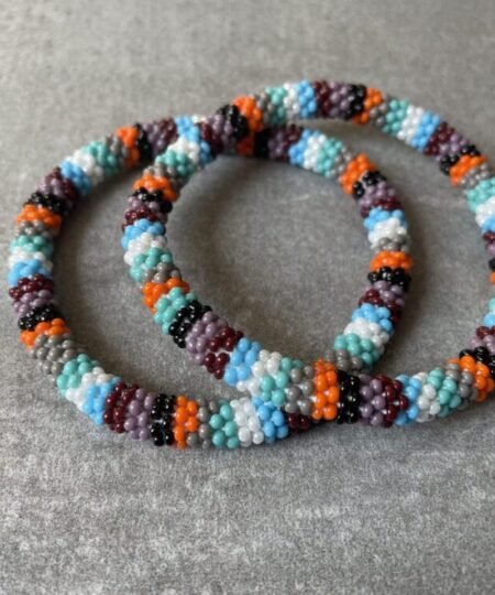 Nepal armbånd er en inspirerende og fascinerende smykkegenre, der vækker interessen hos smykkeentusiaster over hele verden. Disse håndlavede armbånd er kunstværker, der udstråler autenticitet, skønhed og dyb symbolik. Lad os dykke ned i den betagende verden af Nepal armbånd og udforske, hvad der gør dem så unikke og eftertragtede. Hvert Nepal armbånd er unikt, og det er netop denne individualitet, der appellerer til mange. Armbåndene er ofte skabt af dygtige nepalesiske håndværkere, der gennem generationer har forfinet deres teknikker til at skabe smykker af høj kvalitet. Disse håndværkere bruger traditionelle metoder, som har været en del af Nepals kultur og historie i århundreder. Processen er omhyggelig og kræver en stor grad af præcision og tålmodighed, hvilket gør hvert armbånd til en kærlighedsfyldt skabelse. Nepal armbånd er kendt for deres farverige og levende design. De er ofte dekoreret med perler, ædelstene, træ, metal eller andre naturlige materialer, hvilket giver dem et unikt udseende. Hvert enkelt element, der anvendes i armbåndene, er udvalgt omhyggeligt for at skabe en harmonisk kombination af farver og teksturer. Disse elementer er ofte inspireret af Nepals rige natur og kultur, hvilket giver armbåndene en autentisk følelse og en stærk forbindelse til landet. Symbolik spiller også en vigtig rolle i Nepal armbåndenes popularitet. Mange af armbåndene har indgraverede mønstre eller symboler, der repræsenterer vigtige aspekter af Nepals traditioner og spiritualitet. Disse symboler kan have betydning for held, lykke, kærlighed, beskyttelse eller en dybere forbindelse til naturen. At bære et Nepal armbånd kan derfor have en dybere betydning for bæreren og kan fungere som en påmindelse om deres forbindelse til Nepals rige arv. Nepal armbånd er ikke kun smukke smykker, men de har også en stærk social og kulturel betydning. Mange af disse smykker er håndlavede af kvinder, der er en del af samfundet i landområderne i Nepal. Produktionen af armbåndene giver disse kvinder mulighed for at skabe en bæredygtig indkomst, forbedre deres levevilkår og styrke deres selvstændighed. Når du køber et Nepal armbånd, bidrager du derfor til at støtte en positiv social indvirkning og bevare traditionelle håndværksmæssige metoder. Udover deres kulturelle og sociale betydning er Nepal armbånd også en favorit blandt modebevidste enkeltpersoner, der ønsker at tilføje en unik og autentisk touch til deres stil. Disse armbånd kan styles på utallige måder, uanset om du ønsker at skabe et bohemeinspireret look, en farverig festlig stil eller en subtil og elegant kombination. Der er et Nepal armbånd til enhver lejlighed og enhver personlig præference. I det store udvalg af smykker, der findes i dagens marked, skiller Nepal armbånd sig ud som en særlig perle. Deres håndlavede karakter, farverige design, dybe symbolik og sociale indvirkning gør dem til mere end bare smykker - de er en form for kunst og kultur, der fortæller historien om Nepal og dets folk. Ved at bære et Nepal armbånd, bærer du også med dig en del af dette rige og inspirerende land. Så uanset om du leder efter en meningsfuld gave eller ønsker at berige din egen smykkesamling, vil et Nepal armbånd være et mindeværdigt og værdsat valg.