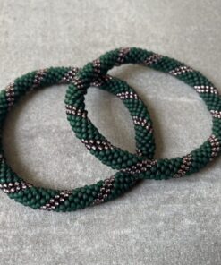 Nepal armbånd er en inspirerende og fascinerende smykkegenre, der vækker interessen hos smykkeentusiaster over hele verden. Disse håndlavede armbånd er kunstværker, der udstråler autenticitet, skønhed og dyb symbolik. Lad os dykke ned i den betagende verden af Nepal armbånd og udforske, hvad der gør dem så unikke og eftertragtede. Hvert Nepal armbånd er unikt, og det er netop denne individualitet, der appellerer til mange. Armbåndene er ofte skabt af dygtige nepalesiske håndværkere, der gennem generationer har forfinet deres teknikker til at skabe smykker af høj kvalitet. Disse håndværkere bruger traditionelle metoder, som har været en del af Nepals kultur og historie i århundreder. Processen er omhyggelig og kræver en stor grad af præcision og tålmodighed, hvilket gør hvert armbånd til en kærlighedsfyldt skabelse. Nepal armbånd er kendt for deres farverige og levende design. De er ofte dekoreret med perler, ædelstene, træ, metal eller andre naturlige materialer, hvilket giver dem et unikt udseende. Hvert enkelt element, der anvendes i armbåndene, er udvalgt omhyggeligt for at skabe en harmonisk kombination af farver og teksturer. Disse elementer er ofte inspireret af Nepals rige natur og kultur, hvilket giver armbåndene en autentisk følelse og en stærk forbindelse til landet. Symbolik spiller også en vigtig rolle i Nepal armbåndenes popularitet. Mange af armbåndene har indgraverede mønstre eller symboler, der repræsenterer vigtige aspekter af Nepals traditioner og spiritualitet. Disse symboler kan have betydning for held, lykke, kærlighed, beskyttelse eller en dybere forbindelse til naturen. At bære et Nepal armbånd kan derfor have en dybere betydning for bæreren og kan fungere som en påmindelse om deres forbindelse til Nepals rige arv. Nepal armbånd er ikke kun smukke smykker, men de har også en stærk social og kulturel betydning. Mange af disse smykker er håndlavede af kvinder, der er en del af samfundet i landområderne i Nepal. Produktionen af armbåndene giver disse kvinder mulighed for at skabe en bæredygtig indkomst, forbedre deres levevilkår og styrke deres selvstændighed. Når du køber et Nepal armbånd, bidrager du derfor til at støtte en positiv social indvirkning og bevare traditionelle håndværksmæssige metoder. Udover deres kulturelle og sociale betydning er Nepal armbånd også en favorit blandt modebevidste enkeltpersoner, der ønsker at tilføje en unik og autentisk touch til deres stil. Disse armbånd kan styles på utallige måder, uanset om du ønsker at skabe et bohemeinspireret look, en farverig festlig stil eller en subtil og elegant kombination. Der er et Nepal armbånd til enhver lejlighed og enhver personlig præference. I det store udvalg af smykker, der findes i dagens marked, skiller Nepal armbånd sig ud som en særlig perle. Deres håndlavede karakter, farverige design, dybe symbolik og sociale indvirkning gør dem til mere end bare smykker - de er en form for kunst og kultur, der fortæller historien om Nepal og dets folk. Ved at bære et Nepal armbånd, bærer du også med dig en del af dette rige og inspirerende land. Så uanset om du leder efter en meningsfuld gave eller ønsker at berige din egen smykkesamling, vil et Nepal armbånd være et mindeværdigt og værdsat valg.