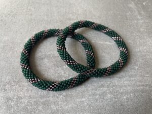 Nepal armbånd er en inspirerende og fascinerende smykkegenre, der vækker interessen hos smykkeentusiaster over hele verden. Disse håndlavede armbånd er kunstværker, der udstråler autenticitet, skønhed og dyb symbolik. Lad os dykke ned i den betagende verden af Nepal armbånd og udforske, hvad der gør dem så unikke og eftertragtede. Hvert Nepal armbånd er unikt, og det er netop denne individualitet, der appellerer til mange. Armbåndene er ofte skabt af dygtige nepalesiske håndværkere, der gennem generationer har forfinet deres teknikker til at skabe smykker af høj kvalitet. Disse håndværkere bruger traditionelle metoder, som har været en del af Nepals kultur og historie i århundreder. Processen er omhyggelig og kræver en stor grad af præcision og tålmodighed, hvilket gør hvert armbånd til en kærlighedsfyldt skabelse. Nepal armbånd er kendt for deres farverige og levende design. De er ofte dekoreret med perler, ædelstene, træ, metal eller andre naturlige materialer, hvilket giver dem et unikt udseende. Hvert enkelt element, der anvendes i armbåndene, er udvalgt omhyggeligt for at skabe en harmonisk kombination af farver og teksturer. Disse elementer er ofte inspireret af Nepals rige natur og kultur, hvilket giver armbåndene en autentisk følelse og en stærk forbindelse til landet. Symbolik spiller også en vigtig rolle i Nepal armbåndenes popularitet. Mange af armbåndene har indgraverede mønstre eller symboler, der repræsenterer vigtige aspekter af Nepals traditioner og spiritualitet. Disse symboler kan have betydning for held, lykke, kærlighed, beskyttelse eller en dybere forbindelse til naturen. At bære et Nepal armbånd kan derfor have en dybere betydning for bæreren og kan fungere som en påmindelse om deres forbindelse til Nepals rige arv. Nepal armbånd er ikke kun smukke smykker, men de har også en stærk social og kulturel betydning. Mange af disse smykker er håndlavede af kvinder, der er en del af samfundet i landområderne i Nepal. Produktionen af armbåndene giver disse kvinder mulighed for at skabe en bæredygtig indkomst, forbedre deres levevilkår og styrke deres selvstændighed. Når du køber et Nepal armbånd, bidrager du derfor til at støtte en positiv social indvirkning og bevare traditionelle håndværksmæssige metoder. Udover deres kulturelle og sociale betydning er Nepal armbånd også en favorit blandt modebevidste enkeltpersoner, der ønsker at tilføje en unik og autentisk touch til deres stil. Disse armbånd kan styles på utallige måder, uanset om du ønsker at skabe et bohemeinspireret look, en farverig festlig stil eller en subtil og elegant kombination. Der er et Nepal armbånd til enhver lejlighed og enhver personlig præference. I det store udvalg af smykker, der findes i dagens marked, skiller Nepal armbånd sig ud som en særlig perle. Deres håndlavede karakter, farverige design, dybe symbolik og sociale indvirkning gør dem til mere end bare smykker - de er en form for kunst og kultur, der fortæller historien om Nepal og dets folk. Ved at bære et Nepal armbånd, bærer du også med dig en del af dette rige og inspirerende land. Så uanset om du leder efter en meningsfuld gave eller ønsker at berige din egen smykkesamling, vil et Nepal armbånd være et mindeværdigt og værdsat valg.