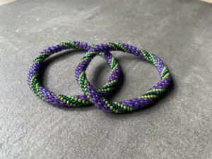 Nepal armbånd er en inspirerende og fascinerende smykkegenre, der vækker interessen hos smykkeentusiaster over hele verden. Disse håndlavede armbånd er kunstværker, der udstråler autenticitet, skønhed og dyb symbolik. Lad os dykke ned i den betagende verden af Nepal armbånd og udforske, hvad der gør dem så unikke og eftertragtede. Hvert Nepal armbånd er unikt, og det er netop denne individualitet, der appellerer til mange. Armbåndene er ofte skabt af dygtige nepalesiske håndværkere, der gennem generationer har forfinet deres teknikker til at skabe smykker af høj kvalitet. Disse håndværkere bruger traditionelle metoder, som har været en del af Nepals kultur og historie i århundreder. Processen er omhyggelig og kræver en stor grad af præcision og tålmodighed, hvilket gør hvert armbånd til en kærlighedsfyldt skabelse. Nepal armbånd er kendt for deres farverige og levende design. De er ofte dekoreret med perler, ædelstene, træ, metal eller andre naturlige materialer, hvilket giver dem et unikt udseende. Hvert enkelt element, der anvendes i armbåndene, er udvalgt omhyggeligt for at skabe en harmonisk kombination af farver og teksturer. Disse elementer er ofte inspireret af Nepals rige natur og kultur, hvilket giver armbåndene en autentisk følelse og en stærk forbindelse til landet. Symbolik spiller også en vigtig rolle i Nepal armbåndenes popularitet. Mange af armbåndene har indgraverede mønstre eller symboler, der repræsenterer vigtige aspekter af Nepals traditioner og spiritualitet. Disse symboler kan have betydning for held, lykke, kærlighed, beskyttelse eller en dybere forbindelse til naturen. At bære et Nepal armbånd kan derfor have en dybere betydning for bæreren og kan fungere som en påmindelse om deres forbindelse til Nepals rige arv. Nepal armbånd er ikke kun smukke smykker, men de har også en stærk social og kulturel betydning. Mange af disse smykker er håndlavede af kvinder, der er en del af samfundet i landområderne i Nepal. Produktionen af armbåndene giver disse kvinder mulighed for at skabe en bæredygtig indkomst, forbedre deres levevilkår og styrke deres selvstændighed. Når du køber et Nepal armbånd, bidrager du derfor til at støtte en positiv social indvirkning og bevare traditionelle håndværksmæssige metoder. Udover deres kulturelle og sociale betydning er Nepal armbånd også en favorit blandt modebevidste enkeltpersoner, der ønsker at tilføje en unik og autentisk touch til deres stil. Disse armbånd kan styles på utallige måder, uanset om du ønsker at skabe et bohemeinspireret look, en farverig festlig stil eller en subtil og elegant kombination. Der er et Nepal armbånd til enhver lejlighed og enhver personlig præference. I det store udvalg af smykker, der findes i dagens marked, skiller Nepal armbånd sig ud som en særlig perle. Deres håndlavede karakter, farverige design, dybe symbolik og sociale indvirkning gør dem til mere end bare smykker - de er en form for kunst og kultur, der fortæller historien om Nepal og dets folk. Ved at bære et Nepal armbånd, bærer du også med dig en del af dette rige og inspirerende land. Så uanset om du leder efter en meningsfuld gave eller ønsker at berige din egen smykkesamling, vil et Nepal armbånd være et mindeværdigt og værdsat valg.