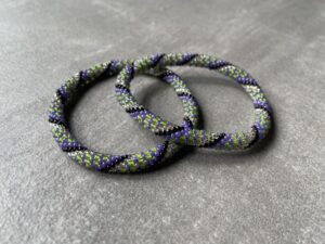 Nepal armbånd er en inspirerende og fascinerende smykkegenre, der vækker interessen hos smykkeentusiaster over hele verden. Disse håndlavede armbånd er kunstværker, der udstråler autenticitet, skønhed og dyb symbolik. Lad os dykke ned i den betagende verden af Nepal armbånd og udforske, hvad der gør dem så unikke og eftertragtede. Hvert Nepal armbånd er unikt, og det er netop denne individualitet, der appellerer til mange. Armbåndene er ofte skabt af dygtige nepalesiske håndværkere, der gennem generationer har forfinet deres teknikker til at skabe smykker af høj kvalitet. Disse håndværkere bruger traditionelle metoder, som har været en del af Nepals kultur og historie i århundreder. Processen er omhyggelig og kræver en stor grad af præcision og tålmodighed, hvilket gør hvert armbånd til en kærlighedsfyldt skabelse. Nepal armbånd er kendt for deres farverige og levende design. De er ofte dekoreret med perler, ædelstene, træ, metal eller andre naturlige materialer, hvilket giver dem et unikt udseende. Hvert enkelt element, der anvendes i armbåndene, er udvalgt omhyggeligt for at skabe en harmonisk kombination af farver og teksturer. Disse elementer er ofte inspireret af Nepals rige natur og kultur, hvilket giver armbåndene en autentisk følelse og en stærk forbindelse til landet. Symbolik spiller også en vigtig rolle i Nepal armbåndenes popularitet. Mange af armbåndene har indgraverede mønstre eller symboler, der repræsenterer vigtige aspekter af Nepals traditioner og spiritualitet. Disse symboler kan have betydning for held, lykke, kærlighed, beskyttelse eller en dybere forbindelse til naturen. At bære et Nepal armbånd kan derfor have en dybere betydning for bæreren og kan fungere som en påmindelse om deres forbindelse til Nepals rige arv. Nepal armbånd er ikke kun smukke smykker, men de har også en stærk social og kulturel betydning. Mange af disse smykker er håndlavede af kvinder, der er en del af samfundet i landområderne i Nepal. Produktionen af armbåndene giver disse kvinder mulighed for at skabe en bæredygtig indkomst, forbedre deres levevilkår og styrke deres selvstændighed. Når du køber et Nepal armbånd, bidrager du derfor til at støtte en positiv social indvirkning og bevare traditionelle håndværksmæssige metoder. Udover deres kulturelle og sociale betydning er Nepal armbånd også en favorit blandt modebevidste enkeltpersoner, der ønsker at tilføje en unik og autentisk touch til deres stil. Disse armbånd kan styles på utallige måder, uanset om du ønsker at skabe et bohemeinspireret look, en farverig festlig stil eller en subtil og elegant kombination. Der er et Nepal armbånd til enhver lejlighed og enhver personlig præference. I det store udvalg af smykker, der findes i dagens marked, skiller Nepal armbånd sig ud som en særlig perle. Deres håndlavede karakter, farverige design, dybe symbolik og sociale indvirkning gør dem til mere end bare smykker - de er en form for kunst og kultur, der fortæller historien om Nepal og dets folk. Ved at bære et Nepal armbånd, bærer du også med dig en del af dette rige og inspirerende land. Så uanset om du leder efter en meningsfuld gave eller ønsker at berige din egen smykkesamling, vil et Nepal armbånd være et mindeværdigt og værdsat valg.