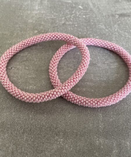 Nepal armbånd er en inspirerende og fascinerende smykkegenre, der vækker interessen hos smykkeentusiaster over hele verden. Disse håndlavede armbånd er kunstværker, der udstråler autenticitet, skønhed og dyb symbolik. Lad os dykke ned i den betagende verden af Nepal armbånd og udforske, hvad der gør dem så unikke og eftertragtede. Hvert Nepal armbånd er unikt, og det er netop denne individualitet, der appellerer til mange. Armbåndene er ofte skabt af dygtige nepalesiske håndværkere, der gennem generationer har forfinet deres teknikker til at skabe smykker af høj kvalitet. Disse håndværkere bruger traditionelle metoder, som har været en del af Nepals kultur og historie i århundreder. Processen er omhyggelig og kræver en stor grad af præcision og tålmodighed, hvilket gør hvert armbånd til en kærlighedsfyldt skabelse. Nepal armbånd er kendt for deres farverige og levende design. De er ofte dekoreret med perler, ædelstene, træ, metal eller andre naturlige materialer, hvilket giver dem et unikt udseende. Hvert enkelt element, der anvendes i armbåndene, er udvalgt omhyggeligt for at skabe en harmonisk kombination af farver og teksturer. Disse elementer er ofte inspireret af Nepals rige natur og kultur, hvilket giver armbåndene en autentisk følelse og en stærk forbindelse til landet. Symbolik spiller også en vigtig rolle i Nepal armbåndenes popularitet. Mange af armbåndene har indgraverede mønstre eller symboler, der repræsenterer vigtige aspekter af Nepals traditioner og spiritualitet. Disse symboler kan have betydning for held, lykke, kærlighed, beskyttelse eller en dybere forbindelse til naturen. At bære et Nepal armbånd kan derfor have en dybere betydning for bæreren og kan fungere som en påmindelse om deres forbindelse til Nepals rige arv. Nepal armbånd er ikke kun smukke smykker, men de har også en stærk social og kulturel betydning. Mange af disse smykker er håndlavede af kvinder, der er en del af samfundet i landområderne i Nepal. Produktionen af armbåndene giver disse kvinder mulighed for at skabe en bæredygtig indkomst, forbedre deres levevilkår og styrke deres selvstændighed. Når du køber et Nepal armbånd, bidrager du derfor til at støtte en positiv social indvirkning og bevare traditionelle håndværksmæssige metoder. Udover deres kulturelle og sociale betydning er Nepal armbånd også en favorit blandt modebevidste enkeltpersoner, der ønsker at tilføje en unik og autentisk touch til deres stil. Disse armbånd kan styles på utallige måder, uanset om du ønsker at skabe et bohemeinspireret look, en farverig festlig stil eller en subtil og elegant kombination. Der er et Nepal armbånd til enhver lejlighed og enhver personlig præference. I det store udvalg af smykker, der findes i dagens marked, skiller Nepal armbånd sig ud som en særlig perle. Deres håndlavede karakter, farverige design, dybe symbolik og sociale indvirkning gør dem til mere end bare smykker - de er en form for kunst og kultur, der fortæller historien om Nepal og dets folk. Ved at bære et Nepal armbånd, bærer du også med dig en del af dette rige og inspirerende land. Så uanset om du leder efter en meningsfuld gave eller ønsker at berige din egen smykkesamling, vil et Nepal armbånd være et mindeværdigt og værdsat valg.