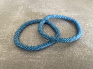 Nepal armbånd er en inspirerende og fascinerende smykkegenre, der vækker interessen hos smykkeentusiaster over hele verden. Disse håndlavede armbånd er kunstværker, der udstråler autenticitet, skønhed og dyb symbolik. Lad os dykke ned i den betagende verden af Nepal armbånd og udforske, hvad der gør dem så unikke og eftertragtede. Hvert Nepal armbånd er unikt, og det er netop denne individualitet, der appellerer til mange. Armbåndene er ofte skabt af dygtige nepalesiske håndværkere, der gennem generationer har forfinet deres teknikker til at skabe smykker af høj kvalitet. Disse håndværkere bruger traditionelle metoder, som har været en del af Nepals kultur og historie i århundreder. Processen er omhyggelig og kræver en stor grad af præcision og tålmodighed, hvilket gør hvert armbånd til en kærlighedsfyldt skabelse. Nepal armbånd er kendt for deres farverige og levende design. De er ofte dekoreret med perler, ædelstene, træ, metal eller andre naturlige materialer, hvilket giver dem et unikt udseende. Hvert enkelt element, der anvendes i armbåndene, er udvalgt omhyggeligt for at skabe en harmonisk kombination af farver og teksturer. Disse elementer er ofte inspireret af Nepals rige natur og kultur, hvilket giver armbåndene en autentisk følelse og en stærk forbindelse til landet. Symbolik spiller også en vigtig rolle i Nepal armbåndenes popularitet. Mange af armbåndene har indgraverede mønstre eller symboler, der repræsenterer vigtige aspekter af Nepals traditioner og spiritualitet. Disse symboler kan have betydning for held, lykke, kærlighed, beskyttelse eller en dybere forbindelse til naturen. At bære et Nepal armbånd kan derfor have en dybere betydning for bæreren og kan fungere som en påmindelse om deres forbindelse til Nepals rige arv. Nepal armbånd er ikke kun smukke smykker, men de har også en stærk social og kulturel betydning. Mange af disse smykker er håndlavede af kvinder, der er en del af samfundet i landområderne i Nepal. Produktionen af armbåndene giver disse kvinder mulighed for at skabe en bæredygtig indkomst, forbedre deres levevilkår og styrke deres selvstændighed. Når du køber et Nepal armbånd, bidrager du derfor til at støtte en positiv social indvirkning og bevare traditionelle håndværksmæssige metoder. Udover deres kulturelle og sociale betydning er Nepal armbånd også en favorit blandt modebevidste enkeltpersoner, der ønsker at tilføje en unik og autentisk touch til deres stil. Disse armbånd kan styles på utallige måder, uanset om du ønsker at skabe et bohemeinspireret look, en farverig festlig stil eller en subtil og elegant kombination. Der er et Nepal armbånd til enhver lejlighed og enhver personlig præference. I det store udvalg af smykker, der findes i dagens marked, skiller Nepal armbånd sig ud som en særlig perle. Deres håndlavede karakter, farverige design, dybe symbolik og sociale indvirkning gør dem til mere end bare smykker - de er en form for kunst og kultur, der fortæller historien om Nepal og dets folk. Ved at bære et Nepal armbånd, bærer du også med dig en del af dette rige og inspirerende land. Så uanset om du leder efter en meningsfuld gave eller ønsker at berige din egen smykkesamling, vil et Nepal armbånd være et mindeværdigt og værdsat valg.