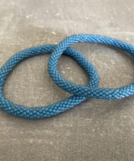 Nepal armbånd er en inspirerende og fascinerende smykkegenre, der vækker interessen hos smykkeentusiaster over hele verden. Disse håndlavede armbånd er kunstværker, der udstråler autenticitet, skønhed og dyb symbolik. Lad os dykke ned i den betagende verden af Nepal armbånd og udforske, hvad der gør dem så unikke og eftertragtede. Hvert Nepal armbånd er unikt, og det er netop denne individualitet, der appellerer til mange. Armbåndene er ofte skabt af dygtige nepalesiske håndværkere, der gennem generationer har forfinet deres teknikker til at skabe smykker af høj kvalitet. Disse håndværkere bruger traditionelle metoder, som har været en del af Nepals kultur og historie i århundreder. Processen er omhyggelig og kræver en stor grad af præcision og tålmodighed, hvilket gør hvert armbånd til en kærlighedsfyldt skabelse. Nepal armbånd er kendt for deres farverige og levende design. De er ofte dekoreret med perler, ædelstene, træ, metal eller andre naturlige materialer, hvilket giver dem et unikt udseende. Hvert enkelt element, der anvendes i armbåndene, er udvalgt omhyggeligt for at skabe en harmonisk kombination af farver og teksturer. Disse elementer er ofte inspireret af Nepals rige natur og kultur, hvilket giver armbåndene en autentisk følelse og en stærk forbindelse til landet. Symbolik spiller også en vigtig rolle i Nepal armbåndenes popularitet. Mange af armbåndene har indgraverede mønstre eller symboler, der repræsenterer vigtige aspekter af Nepals traditioner og spiritualitet. Disse symboler kan have betydning for held, lykke, kærlighed, beskyttelse eller en dybere forbindelse til naturen. At bære et Nepal armbånd kan derfor have en dybere betydning for bæreren og kan fungere som en påmindelse om deres forbindelse til Nepals rige arv. Nepal armbånd er ikke kun smukke smykker, men de har også en stærk social og kulturel betydning. Mange af disse smykker er håndlavede af kvinder, der er en del af samfundet i landområderne i Nepal. Produktionen af armbåndene giver disse kvinder mulighed for at skabe en bæredygtig indkomst, forbedre deres levevilkår og styrke deres selvstændighed. Når du køber et Nepal armbånd, bidrager du derfor til at støtte en positiv social indvirkning og bevare traditionelle håndværksmæssige metoder. Udover deres kulturelle og sociale betydning er Nepal armbånd også en favorit blandt modebevidste enkeltpersoner, der ønsker at tilføje en unik og autentisk touch til deres stil. Disse armbånd kan styles på utallige måder, uanset om du ønsker at skabe et bohemeinspireret look, en farverig festlig stil eller en subtil og elegant kombination. Der er et Nepal armbånd til enhver lejlighed og enhver personlig præference. I det store udvalg af smykker, der findes i dagens marked, skiller Nepal armbånd sig ud som en særlig perle. Deres håndlavede karakter, farverige design, dybe symbolik og sociale indvirkning gør dem til mere end bare smykker - de er en form for kunst og kultur, der fortæller historien om Nepal og dets folk. Ved at bære et Nepal armbånd, bærer du også med dig en del af dette rige og inspirerende land. Så uanset om du leder efter en meningsfuld gave eller ønsker at berige din egen smykkesamling, vil et Nepal armbånd være et mindeværdigt og værdsat valg.