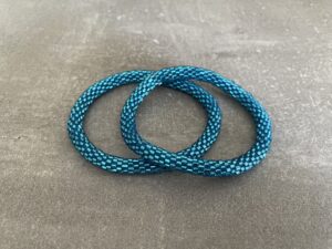 Nepal armbånd er en inspirerende og fascinerende smykkegenre, der vækker interessen hos smykkeentusiaster over hele verden. Disse håndlavede armbånd er kunstværker, der udstråler autenticitet, skønhed og dyb symbolik. Lad os dykke ned i den betagende verden af Nepal armbånd og udforske, hvad der gør dem så unikke og eftertragtede. Hvert Nepal armbånd er unikt, og det er netop denne individualitet, der appellerer til mange. Armbåndene er ofte skabt af dygtige nepalesiske håndværkere, der gennem generationer har forfinet deres teknikker til at skabe smykker af høj kvalitet. Disse håndværkere bruger traditionelle metoder, som har været en del af Nepals kultur og historie i århundreder. Processen er omhyggelig og kræver en stor grad af præcision og tålmodighed, hvilket gør hvert armbånd til en kærlighedsfyldt skabelse. Nepal armbånd er kendt for deres farverige og levende design. De er ofte dekoreret med perler, ædelstene, træ, metal eller andre naturlige materialer, hvilket giver dem et unikt udseende. Hvert enkelt element, der anvendes i armbåndene, er udvalgt omhyggeligt for at skabe en harmonisk kombination af farver og teksturer. Disse elementer er ofte inspireret af Nepals rige natur og kultur, hvilket giver armbåndene en autentisk følelse og en stærk forbindelse til landet. Symbolik spiller også en vigtig rolle i Nepal armbåndenes popularitet. Mange af armbåndene har indgraverede mønstre eller symboler, der repræsenterer vigtige aspekter af Nepals traditioner og spiritualitet. Disse symboler kan have betydning for held, lykke, kærlighed, beskyttelse eller en dybere forbindelse til naturen. At bære et Nepal armbånd kan derfor have en dybere betydning for bæreren og kan fungere som en påmindelse om deres forbindelse til Nepals rige arv. Nepal armbånd er ikke kun smukke smykker, men de har også en stærk social og kulturel betydning. Mange af disse smykker er håndlavede af kvinder, der er en del af samfundet i landområderne i Nepal. Produktionen af armbåndene giver disse kvinder mulighed for at skabe en bæredygtig indkomst, forbedre deres levevilkår og styrke deres selvstændighed. Når du køber et Nepal armbånd, bidrager du derfor til at støtte en positiv social indvirkning og bevare traditionelle håndværksmæssige metoder. Udover deres kulturelle og sociale betydning er Nepal armbånd også en favorit blandt modebevidste enkeltpersoner, der ønsker at tilføje en unik og autentisk touch til deres stil. Disse armbånd kan styles på utallige måder, uanset om du ønsker at skabe et bohemeinspireret look, en farverig festlig stil eller en subtil og elegant kombination. Der er et Nepal armbånd til enhver lejlighed og enhver personlig præference. I det store udvalg af smykker, der findes i dagens marked, skiller Nepal armbånd sig ud som en særlig perle. Deres håndlavede karakter, farverige design, dybe symbolik og sociale indvirkning gør dem til mere end bare smykker - de er en form for kunst og kultur, der fortæller historien om Nepal og dets folk. Ved at bære et Nepal armbånd, bærer du også med dig en del af dette rige og inspirerende land. Så uanset om du leder efter en meningsfuld gave eller ønsker at berige din egen smykkesamling, vil et Nepal armbånd være et mindeværdigt og værdsat valg.