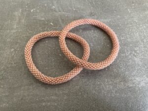 Nepal armbånd er en inspirerende og fascinerende smykkegenre, der vækker interessen hos smykkeentusiaster over hele verden. Disse håndlavede armbånd er kunstværker, der udstråler autenticitet, skønhed og dyb symbolik. Lad os dykke ned i den betagende verden af Nepal armbånd og udforske, hvad der gør dem så unikke og eftertragtede. Hvert Nepal armbånd er unikt, og det er netop denne individualitet, der appellerer til mange. Armbåndene er ofte skabt af dygtige nepalesiske håndværkere, der gennem generationer har forfinet deres teknikker til at skabe smykker af høj kvalitet. Disse håndværkere bruger traditionelle metoder, som har været en del af Nepals kultur og historie i århundreder. Processen er omhyggelig og kræver en stor grad af præcision og tålmodighed, hvilket gør hvert armbånd til en kærlighedsfyldt skabelse. Nepal armbånd er kendt for deres farverige og levende design. De er ofte dekoreret med perler, ædelstene, træ, metal eller andre naturlige materialer, hvilket giver dem et unikt udseende. Hvert enkelt element, der anvendes i armbåndene, er udvalgt omhyggeligt for at skabe en harmonisk kombination af farver og teksturer. Disse elementer er ofte inspireret af Nepals rige natur og kultur, hvilket giver armbåndene en autentisk følelse og en stærk forbindelse til landet. Symbolik spiller også en vigtig rolle i Nepal armbåndenes popularitet. Mange af armbåndene har indgraverede mønstre eller symboler, der repræsenterer vigtige aspekter af Nepals traditioner og spiritualitet. Disse symboler kan have betydning for held, lykke, kærlighed, beskyttelse eller en dybere forbindelse til naturen. At bære et Nepal armbånd kan derfor have en dybere betydning for bæreren og kan fungere som en påmindelse om deres forbindelse til Nepals rige arv. Nepal armbånd er ikke kun smukke smykker, men de har også en stærk social og kulturel betydning. Mange af disse smykker er håndlavede af kvinder, der er en del af samfundet i landområderne i Nepal. Produktionen af armbåndene giver disse kvinder mulighed for at skabe en bæredygtig indkomst, forbedre deres levevilkår og styrke deres selvstændighed. Når du køber et Nepal armbånd, bidrager du derfor til at støtte en positiv social indvirkning og bevare traditionelle håndværksmæssige metoder. Udover deres kulturelle og sociale betydning er Nepal armbånd også en favorit blandt modebevidste enkeltpersoner, der ønsker at tilføje en unik og autentisk touch til deres stil. Disse armbånd kan styles på utallige måder, uanset om du ønsker at skabe et bohemeinspireret look, en farverig festlig stil eller en subtil og elegant kombination. Der er et Nepal armbånd til enhver lejlighed og enhver personlig præference. I det store udvalg af smykker, der findes i dagens marked, skiller Nepal armbånd sig ud som en særlig perle. Deres håndlavede karakter, farverige design, dybe symbolik og sociale indvirkning gør dem til mere end bare smykker - de er en form for kunst og kultur, der fortæller historien om Nepal og dets folk. Ved at bære et Nepal armbånd, bærer du også med dig en del af dette rige og inspirerende land. Så uanset om du leder efter en meningsfuld gave eller ønsker at berige din egen smykkesamling, vil et Nepal armbånd være et mindeværdigt og værdsat valg.