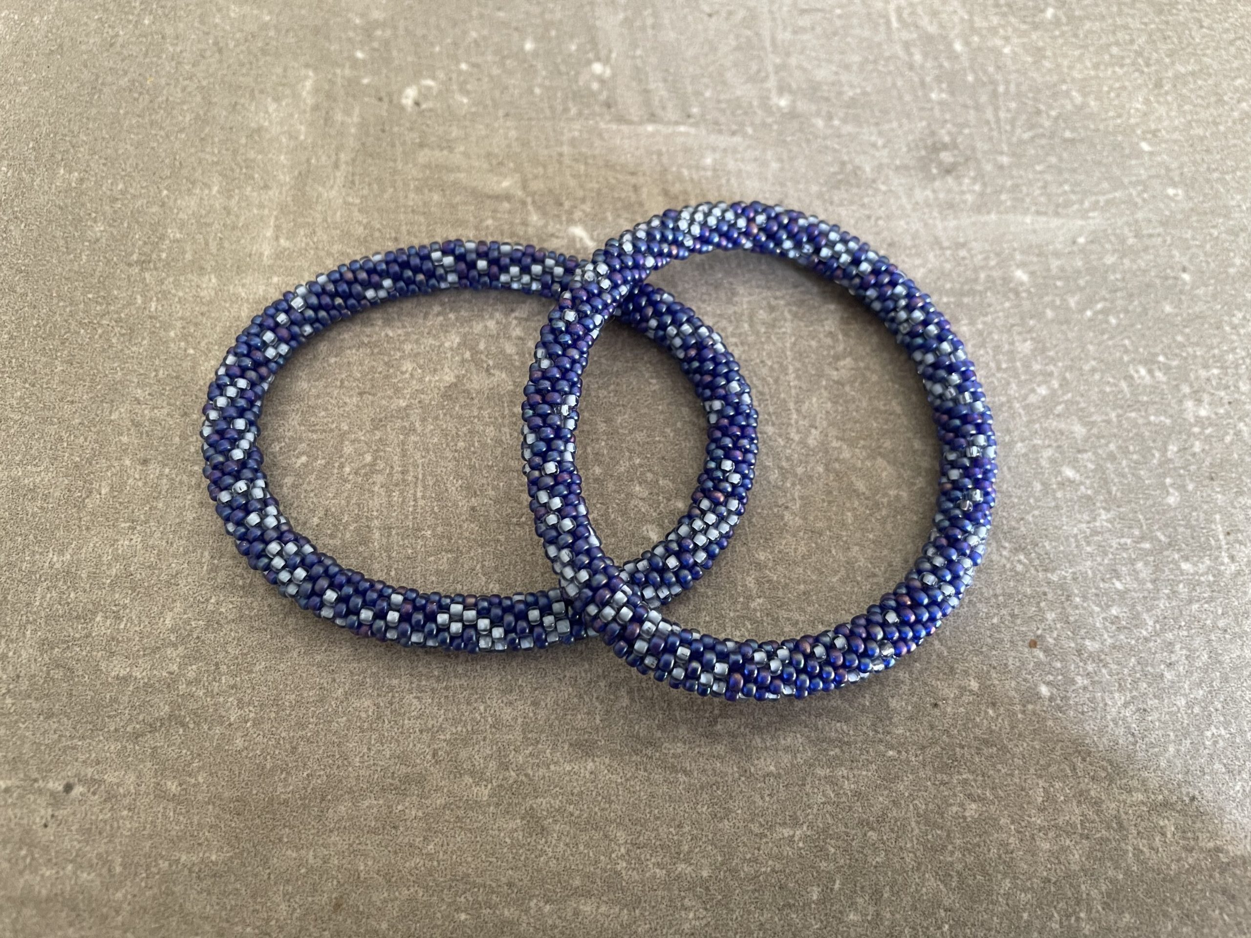 Nepal armbånd er en inspirerende og fascinerende smykkegenre, der vækker interessen hos smykkeentusiaster over hele verden. Disse håndlavede armbånd er kunstværker, der udstråler autenticitet, skønhed og dyb symbolik. Lad os dykke ned i den betagende verden af Nepal armbånd og udforske, hvad der gør dem så unikke og eftertragtede. Hvert Nepal armbånd er unikt, og det er netop denne individualitet, der appellerer til mange. Armbåndene er ofte skabt af dygtige nepalesiske håndværkere, der gennem generationer har forfinet deres teknikker til at skabe smykker af høj kvalitet. Disse håndværkere bruger traditionelle metoder, som har været en del af Nepals kultur og historie i århundreder. Processen er omhyggelig og kræver en stor grad af præcision og tålmodighed, hvilket gør hvert armbånd til en kærlighedsfyldt skabelse. Nepal armbånd er kendt for deres farverige og levende design. De er ofte dekoreret med perler, ædelstene, træ, metal eller andre naturlige materialer, hvilket giver dem et unikt udseende. Hvert enkelt element, der anvendes i armbåndene, er udvalgt omhyggeligt for at skabe en harmonisk kombination af farver og teksturer. Disse elementer er ofte inspireret af Nepals rige natur og kultur, hvilket giver armbåndene en autentisk følelse og en stærk forbindelse til landet. Symbolik spiller også en vigtig rolle i Nepal armbåndenes popularitet. Mange af armbåndene har indgraverede mønstre eller symboler, der repræsenterer vigtige aspekter af Nepals traditioner og spiritualitet. Disse symboler kan have betydning for held, lykke, kærlighed, beskyttelse eller en dybere forbindelse til naturen. At bære et Nepal armbånd kan derfor have en dybere betydning for bæreren og kan fungere som en påmindelse om deres forbindelse til Nepals rige arv. Nepal armbånd er ikke kun smukke smykker, men de har også en stærk social og kulturel betydning. Mange af disse smykker er håndlavede af kvinder, der er en del af samfundet i landområderne i Nepal. Produktionen af armbåndene giver disse kvinder mulighed for at skabe en bæredygtig indkomst, forbedre deres levevilkår og styrke deres selvstændighed. Når du køber et Nepal armbånd, bidrager du derfor til at støtte en positiv social indvirkning og bevare traditionelle håndværksmæssige metoder. Udover deres kulturelle og sociale betydning er Nepal armbånd også en favorit blandt modebevidste enkeltpersoner, der ønsker at tilføje en unik og autentisk touch til deres stil. Disse armbånd kan styles på utallige måder, uanset om du ønsker at skabe et bohemeinspireret look, en farverig festlig stil eller en subtil og elegant kombination. Der er et Nepal armbånd til enhver lejlighed og enhver personlig præference. I det store udvalg af smykker, der findes i dagens marked, skiller Nepal armbånd sig ud som en særlig perle. Deres håndlavede karakter, farverige design, dybe symbolik og sociale indvirkning gør dem til mere end bare smykker - de er en form for kunst og kultur, der fortæller historien om Nepal og dets folk. Ved at bære et Nepal armbånd, bærer du også med dig en del af dette rige og inspirerende land. Så uanset om du leder efter en meningsfuld gave eller ønsker at berige din egen smykkesamling, vil et Nepal armbånd være et mindeværdigt og værdsat valg.