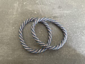 Nepal armbånd er en inspirerende og fascinerende smykkegenre, der vækker interessen hos smykkeentusiaster over hele verden. Disse håndlavede armbånd er kunstværker, der udstråler autenticitet, skønhed og dyb symbolik. Lad os dykke ned i den betagende verden af Nepal armbånd og udforske, hvad der gør dem så unikke og eftertragtede. Hvert Nepal armbånd er unikt, og det er netop denne individualitet, der appellerer til mange. Armbåndene er ofte skabt af dygtige nepalesiske håndværkere, der gennem generationer har forfinet deres teknikker til at skabe smykker af høj kvalitet. Disse håndværkere bruger traditionelle metoder, som har været en del af Nepals kultur og historie i århundreder. Processen er omhyggelig og kræver en stor grad af præcision og tålmodighed, hvilket gør hvert armbånd til en kærlighedsfyldt skabelse. Nepal armbånd er kendt for deres farverige og levende design. De er ofte dekoreret med perler, ædelstene, træ, metal eller andre naturlige materialer, hvilket giver dem et unikt udseende. Hvert enkelt element, der anvendes i armbåndene, er udvalgt omhyggeligt for at skabe en harmonisk kombination af farver og teksturer. Disse elementer er ofte inspireret af Nepals rige natur og kultur, hvilket giver armbåndene en autentisk følelse og en stærk forbindelse til landet. Symbolik spiller også en vigtig rolle i Nepal armbåndenes popularitet. Mange af armbåndene har indgraverede mønstre eller symboler, der repræsenterer vigtige aspekter af Nepals traditioner og spiritualitet. Disse symboler kan have betydning for held, lykke, kærlighed, beskyttelse eller en dybere forbindelse til naturen. At bære et Nepal armbånd kan derfor have en dybere betydning for bæreren og kan fungere som en påmindelse om deres forbindelse til Nepals rige arv. Nepal armbånd er ikke kun smukke smykker, men de har også en stærk social og kulturel betydning. Mange af disse smykker er håndlavede af kvinder, der er en del af samfundet i landområderne i Nepal. Produktionen af armbåndene giver disse kvinder mulighed for at skabe en bæredygtig indkomst, forbedre deres levevilkår og styrke deres selvstændighed. Når du køber et Nepal armbånd, bidrager du derfor til at støtte en positiv social indvirkning og bevare traditionelle håndværksmæssige metoder. Udover deres kulturelle og sociale betydning er Nepal armbånd også en favorit blandt modebevidste enkeltpersoner, der ønsker at tilføje en unik og autentisk touch til deres stil. Disse armbånd kan styles på utallige måder, uanset om du ønsker at skabe et bohemeinspireret look, en farverig festlig stil eller en subtil og elegant kombination. Der er et Nepal armbånd til enhver lejlighed og enhver personlig præference. I det store udvalg af smykker, der findes i dagens marked, skiller Nepal armbånd sig ud som en særlig perle. Deres håndlavede karakter, farverige design, dybe symbolik og sociale indvirkning gør dem til mere end bare smykker - de er en form for kunst og kultur, der fortæller historien om Nepal og dets folk. Ved at bære et Nepal armbånd, bærer du også med dig en del af dette rige og inspirerende land. Så uanset om du leder efter en meningsfuld gave eller ønsker at berige din egen smykkesamling, vil et Nepal armbånd være et mindeværdigt og værdsat valg.