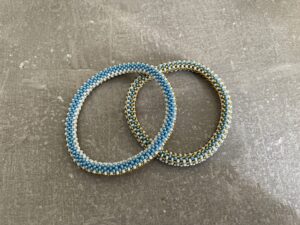 Nepal armbånd er en inspirerende og fascinerende smykkegenre, der vækker interessen hos smykkeentusiaster over hele verden. Disse håndlavede armbånd er kunstværker, der udstråler autenticitet, skønhed og dyb symbolik. Lad os dykke ned i den betagende verden af Nepal armbånd og udforske, hvad der gør dem så unikke og eftertragtede. Hvert Nepal armbånd er unikt, og det er netop denne individualitet, der appellerer til mange. Armbåndene er ofte skabt af dygtige nepalesiske håndværkere, der gennem generationer har forfinet deres teknikker til at skabe smykker af høj kvalitet. Disse håndværkere bruger traditionelle metoder, som har været en del af Nepals kultur og historie i århundreder. Processen er omhyggelig og kræver en stor grad af præcision og tålmodighed, hvilket gør hvert armbånd til en kærlighedsfyldt skabelse. Nepal armbånd er kendt for deres farverige og levende design. De er ofte dekoreret med perler, ædelstene, træ, metal eller andre naturlige materialer, hvilket giver dem et unikt udseende. Hvert enkelt element, der anvendes i armbåndene, er udvalgt omhyggeligt for at skabe en harmonisk kombination af farver og teksturer. Disse elementer er ofte inspireret af Nepals rige natur og kultur, hvilket giver armbåndene en autentisk følelse og en stærk forbindelse til landet. Symbolik spiller også en vigtig rolle i Nepal armbåndenes popularitet. Mange af armbåndene har indgraverede mønstre eller symboler, der repræsenterer vigtige aspekter af Nepals traditioner og spiritualitet. Disse symboler kan have betydning for held, lykke, kærlighed, beskyttelse eller en dybere forbindelse til naturen. At bære et Nepal armbånd kan derfor have en dybere betydning for bæreren og kan fungere som en påmindelse om deres forbindelse til Nepals rige arv. Nepal armbånd er ikke kun smukke smykker, men de har også en stærk social og kulturel betydning. Mange af disse smykker er håndlavede af kvinder, der er en del af samfundet i landområderne i Nepal. Produktionen af armbåndene giver disse kvinder mulighed for at skabe en bæredygtig indkomst, forbedre deres levevilkår og styrke deres selvstændighed. Når du køber et Nepal armbånd, bidrager du derfor til at støtte en positiv social indvirkning og bevare traditionelle håndværksmæssige metoder. Udover deres kulturelle og sociale betydning er Nepal armbånd også en favorit blandt modebevidste enkeltpersoner, der ønsker at tilføje en unik og autentisk touch til deres stil. Disse armbånd kan styles på utallige måder, uanset om du ønsker at skabe et bohemeinspireret look, en farverig festlig stil eller en subtil og elegant kombination. Der er et Nepal armbånd til enhver lejlighed og enhver personlig præference. I det store udvalg af smykker, der findes i dagens marked, skiller Nepal armbånd sig ud som en særlig perle. Deres håndlavede karakter, farverige design, dybe symbolik og sociale indvirkning gør dem til mere end bare smykker - de er en form for kunst og kultur, der fortæller historien om Nepal og dets folk. Ved at bære et Nepal armbånd, bærer du også med dig en del af dette rige og inspirerende land. Så uanset om du leder efter en meningsfuld gave eller ønsker at berige din egen smykkesamling, vil et Nepal armbånd være et mindeværdigt og værdsat valg.