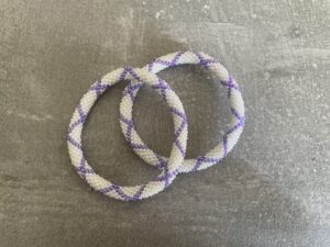 Nepal armbånd er en inspirerende og fascinerende smykkegenre, der vækker interessen hos smykkeentusiaster over hele verden. Disse håndlavede armbånd er kunstværker, der udstråler autenticitet, skønhed og dyb symbolik. Lad os dykke ned i den betagende verden af Nepal armbånd og udforske, hvad der gør dem så unikke og eftertragtede. Hvert Nepal armbånd er unikt, og det er netop denne individualitet, der appellerer til mange. Armbåndene er ofte skabt af dygtige nepalesiske håndværkere, der gennem generationer har forfinet deres teknikker til at skabe smykker af høj kvalitet. Disse håndværkere bruger traditionelle metoder, som har været en del af Nepals kultur og historie i århundreder. Processen er omhyggelig og kræver en stor grad af præcision og tålmodighed, hvilket gør hvert armbånd til en kærlighedsfyldt skabelse. Nepal armbånd er kendt for deres farverige og levende design. De er ofte dekoreret med perler, ædelstene, træ, metal eller andre naturlige materialer, hvilket giver dem et unikt udseende. Hvert enkelt element, der anvendes i armbåndene, er udvalgt omhyggeligt for at skabe en harmonisk kombination af farver og teksturer. Disse elementer er ofte inspireret af Nepals rige natur og kultur, hvilket giver armbåndene en autentisk følelse og en stærk forbindelse til landet. Symbolik spiller også en vigtig rolle i Nepal armbåndenes popularitet. Mange af armbåndene har indgraverede mønstre eller symboler, der repræsenterer vigtige aspekter af Nepals traditioner og spiritualitet. Disse symboler kan have betydning for held, lykke, kærlighed, beskyttelse eller en dybere forbindelse til naturen. At bære et Nepal armbånd kan derfor have en dybere betydning for bæreren og kan fungere som en påmindelse om deres forbindelse til Nepals rige arv. Nepal armbånd er ikke kun smukke smykker, men de har også en stærk social og kulturel betydning. Mange af disse smykker er håndlavede af kvinder, der er en del af samfundet i landområderne i Nepal. Produktionen af armbåndene giver disse kvinder mulighed for at skabe en bæredygtig indkomst, forbedre deres levevilkår og styrke deres selvstændighed. Når du køber et Nepal armbånd, bidrager du derfor til at støtte en positiv social indvirkning og bevare traditionelle håndværksmæssige metoder. Udover deres kulturelle og sociale betydning er Nepal armbånd også en favorit blandt modebevidste enkeltpersoner, der ønsker at tilføje en unik og autentisk touch til deres stil. Disse armbånd kan styles på utallige måder, uanset om du ønsker at skabe et bohemeinspireret look, en farverig festlig stil eller en subtil og elegant kombination. Der er et Nepal armbånd til enhver lejlighed og enhver personlig præference. I det store udvalg af smykker, der findes i dagens marked, skiller Nepal armbånd sig ud som en særlig perle. Deres håndlavede karakter, farverige design, dybe symbolik og sociale indvirkning gør dem til mere end bare smykker - de er en form for kunst og kultur, der fortæller historien om Nepal og dets folk. Ved at bære et Nepal armbånd, bærer du også med dig en del af dette rige og inspirerende land. Så uanset om du leder efter en meningsfuld gave eller ønsker at berige din egen smykkesamling, vil et Nepal armbånd være et mindeværdigt og værdsat valg.