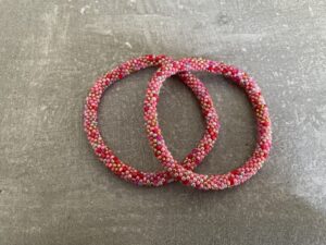 Nepal armbånd er en inspirerende og fascinerende smykkegenre, der vækker interessen hos smykkeentusiaster over hele verden. Disse håndlavede armbånd er kunstværker, der udstråler autenticitet, skønhed og dyb symbolik. Lad os dykke ned i den betagende verden af Nepal armbånd og udforske, hvad der gør dem så unikke og eftertragtede. Hvert Nepal armbånd er unikt, og det er netop denne individualitet, der appellerer til mange. Armbåndene er ofte skabt af dygtige nepalesiske håndværkere, der gennem generationer har forfinet deres teknikker til at skabe smykker af høj kvalitet. Disse håndværkere bruger traditionelle metoder, som har været en del af Nepals kultur og historie i århundreder. Processen er omhyggelig og kræver en stor grad af præcision og tålmodighed, hvilket gør hvert armbånd til en kærlighedsfyldt skabelse. Nepal armbånd er kendt for deres farverige og levende design. De er ofte dekoreret med perler, ædelstene, træ, metal eller andre naturlige materialer, hvilket giver dem et unikt udseende. Hvert enkelt element, der anvendes i armbåndene, er udvalgt omhyggeligt for at skabe en harmonisk kombination af farver og teksturer. Disse elementer er ofte inspireret af Nepals rige natur og kultur, hvilket giver armbåndene en autentisk følelse og en stærk forbindelse til landet. Symbolik spiller også en vigtig rolle i Nepal armbåndenes popularitet. Mange af armbåndene har indgraverede mønstre eller symboler, der repræsenterer vigtige aspekter af Nepals traditioner og spiritualitet. Disse symboler kan have betydning for held, lykke, kærlighed, beskyttelse eller en dybere forbindelse til naturen. At bære et Nepal armbånd kan derfor have en dybere betydning for bæreren og kan fungere som en påmindelse om deres forbindelse til Nepals rige arv. Nepal armbånd er ikke kun smukke smykker, men de har også en stærk social og kulturel betydning. Mange af disse smykker er håndlavede af kvinder, der er en del af samfundet i landområderne i Nepal. Produktionen af armbåndene giver disse kvinder mulighed for at skabe en bæredygtig indkomst, forbedre deres levevilkår og styrke deres selvstændighed. Når du køber et Nepal armbånd, bidrager du derfor til at støtte en positiv social indvirkning og bevare traditionelle håndværksmæssige metoder. Udover deres kulturelle og sociale betydning er Nepal armbånd også en favorit blandt modebevidste enkeltpersoner, der ønsker at tilføje en unik og autentisk touch til deres stil. Disse armbånd kan styles på utallige måder, uanset om du ønsker at skabe et bohemeinspireret look, en farverig festlig stil eller en subtil og elegant kombination. Der er et Nepal armbånd til enhver lejlighed og enhver personlig præference. I det store udvalg af smykker, der findes i dagens marked, skiller Nepal armbånd sig ud som en særlig perle. Deres håndlavede karakter, farverige design, dybe symbolik og sociale indvirkning gør dem til mere end bare smykker - de er en form for kunst og kultur, der fortæller historien om Nepal og dets folk. Ved at bære et Nepal armbånd, bærer du også med dig en del af dette rige og inspirerende land. Så uanset om du leder efter en meningsfuld gave eller ønsker at berige din egen smykkesamling, vil et Nepal armbånd være et mindeværdigt og værdsat valg.
