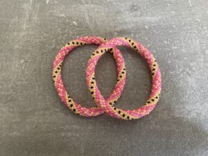 Nepal armbånd er en inspirerende og fascinerende smykkegenre, der vækker interessen hos smykkeentusiaster over hele verden. Disse håndlavede armbånd er kunstværker, der udstråler autenticitet, skønhed og dyb symbolik. Lad os dykke ned i den betagende verden af Nepal armbånd og udforske, hvad der gør dem så unikke og eftertragtede. Hvert Nepal armbånd er unikt, og det er netop denne individualitet, der appellerer til mange. Armbåndene er ofte skabt af dygtige nepalesiske håndværkere, der gennem generationer har forfinet deres teknikker til at skabe smykker af høj kvalitet. Disse håndværkere bruger traditionelle metoder, som har været en del af Nepals kultur og historie i århundreder. Processen er omhyggelig og kræver en stor grad af præcision og tålmodighed, hvilket gør hvert armbånd til en kærlighedsfyldt skabelse. Nepal armbånd er kendt for deres farverige og levende design. De er ofte dekoreret med perler, ædelstene, træ, metal eller andre naturlige materialer, hvilket giver dem et unikt udseende. Hvert enkelt element, der anvendes i armbåndene, er udvalgt omhyggeligt for at skabe en harmonisk kombination af farver og teksturer. Disse elementer er ofte inspireret af Nepals rige natur og kultur, hvilket giver armbåndene en autentisk følelse og en stærk forbindelse til landet. Symbolik spiller også en vigtig rolle i Nepal armbåndenes popularitet. Mange af armbåndene har indgraverede mønstre eller symboler, der repræsenterer vigtige aspekter af Nepals traditioner og spiritualitet. Disse symboler kan have betydning for held, lykke, kærlighed, beskyttelse eller en dybere forbindelse til naturen. At bære et Nepal armbånd kan derfor have en dybere betydning for bæreren og kan fungere som en påmindelse om deres forbindelse til Nepals rige arv. Nepal armbånd er ikke kun smukke smykker, men de har også en stærk social og kulturel betydning. Mange af disse smykker er håndlavede af kvinder, der er en del af samfundet i landområderne i Nepal. Produktionen af armbåndene giver disse kvinder mulighed for at skabe en bæredygtig indkomst, forbedre deres levevilkår og styrke deres selvstændighed. Når du køber et Nepal armbånd, bidrager du derfor til at støtte en positiv social indvirkning og bevare traditionelle håndværksmæssige metoder. Udover deres kulturelle og sociale betydning er Nepal armbånd også en favorit blandt modebevidste enkeltpersoner, der ønsker at tilføje en unik og autentisk touch til deres stil. Disse armbånd kan styles på utallige måder, uanset om du ønsker at skabe et bohemeinspireret look, en farverig festlig stil eller en subtil og elegant kombination. Der er et Nepal armbånd til enhver lejlighed og enhver personlig præference. I det store udvalg af smykker, der findes i dagens marked, skiller Nepal armbånd sig ud som en særlig perle. Deres håndlavede karakter, farverige design, dybe symbolik og sociale indvirkning gør dem til mere end bare smykker - de er en form for kunst og kultur, der fortæller historien om Nepal og dets folk. Ved at bære et Nepal armbånd, bærer du også med dig en del af dette rige og inspirerende land. Så uanset om du leder efter en meningsfuld gave eller ønsker at berige din egen smykkesamling, vil et Nepal armbånd være et mindeværdigt og værdsat valg.