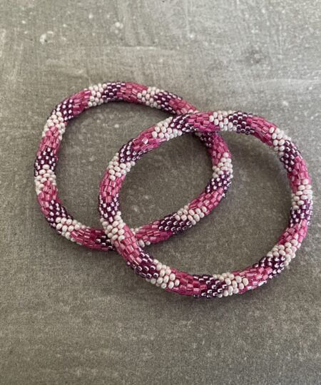 Nepal armbånd er en inspirerende og fascinerende smykkegenre, der vækker interessen hos smykkeentusiaster over hele verden. Disse håndlavede armbånd er kunstværker, der udstråler autenticitet, skønhed og dyb symbolik. Lad os dykke ned i den betagende verden af Nepal armbånd og udforske, hvad der gør dem så unikke og eftertragtede. Hvert Nepal armbånd er unikt, og det er netop denne individualitet, der appellerer til mange. Armbåndene er ofte skabt af dygtige nepalesiske håndværkere, der gennem generationer har forfinet deres teknikker til at skabe smykker af høj kvalitet. Disse håndværkere bruger traditionelle metoder, som har været en del af Nepals kultur og historie i århundreder. Processen er omhyggelig og kræver en stor grad af præcision og tålmodighed, hvilket gør hvert armbånd til en kærlighedsfyldt skabelse. Nepal armbånd er kendt for deres farverige og levende design. De er ofte dekoreret med perler, ædelstene, træ, metal eller andre naturlige materialer, hvilket giver dem et unikt udseende. Hvert enkelt element, der anvendes i armbåndene, er udvalgt omhyggeligt for at skabe en harmonisk kombination af farver og teksturer. Disse elementer er ofte inspireret af Nepals rige natur og kultur, hvilket giver armbåndene en autentisk følelse og en stærk forbindelse til landet. Symbolik spiller også en vigtig rolle i Nepal armbåndenes popularitet. Mange af armbåndene har indgraverede mønstre eller symboler, der repræsenterer vigtige aspekter af Nepals traditioner og spiritualitet. Disse symboler kan have betydning for held, lykke, kærlighed, beskyttelse eller en dybere forbindelse til naturen. At bære et Nepal armbånd kan derfor have en dybere betydning for bæreren og kan fungere som en påmindelse om deres forbindelse til Nepals rige arv. Nepal armbånd er ikke kun smukke smykker, men de har også en stærk social og kulturel betydning. Mange af disse smykker er håndlavede af kvinder, der er en del af samfundet i landområderne i Nepal. Produktionen af armbåndene giver disse kvinder mulighed for at skabe en bæredygtig indkomst, forbedre deres levevilkår og styrke deres selvstændighed. Når du køber et Nepal armbånd, bidrager du derfor til at støtte en positiv social indvirkning og bevare traditionelle håndværksmæssige metoder. Udover deres kulturelle og sociale betydning er Nepal armbånd også en favorit blandt modebevidste enkeltpersoner, der ønsker at tilføje en unik og autentisk touch til deres stil. Disse armbånd kan styles på utallige måder, uanset om du ønsker at skabe et bohemeinspireret look, en farverig festlig stil eller en subtil og elegant kombination. Der er et Nepal armbånd til enhver lejlighed og enhver personlig præference. I det store udvalg af smykker, der findes i dagens marked, skiller Nepal armbånd sig ud som en særlig perle. Deres håndlavede karakter, farverige design, dybe symbolik og sociale indvirkning gør dem til mere end bare smykker - de er en form for kunst og kultur, der fortæller historien om Nepal og dets folk. Ved at bære et Nepal armbånd, bærer du også med dig en del af dette rige og inspirerende land. Så uanset om du leder efter en meningsfuld gave eller ønsker at berige din egen smykkesamling, vil et Nepal armbånd være et mindeværdigt og værdsat valg.