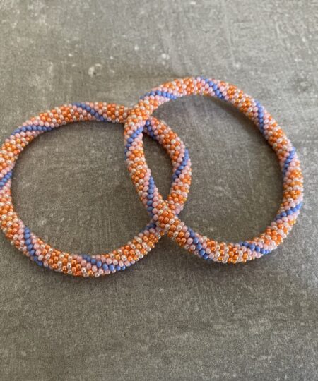 Nepal armbånd er en inspirerende og fascinerende smykkegenre, der vækker interessen hos smykkeentusiaster over hele verden. Disse håndlavede armbånd er kunstværker, der udstråler autenticitet, skønhed og dyb symbolik. Lad os dykke ned i den betagende verden af Nepal armbånd og udforske, hvad der gør dem så unikke og eftertragtede. Hvert Nepal armbånd er unikt, og det er netop denne individualitet, der appellerer til mange. Armbåndene er ofte skabt af dygtige nepalesiske håndværkere, der gennem generationer har forfinet deres teknikker til at skabe smykker af høj kvalitet. Disse håndværkere bruger traditionelle metoder, som har været en del af Nepals kultur og historie i århundreder. Processen er omhyggelig og kræver en stor grad af præcision og tålmodighed, hvilket gør hvert armbånd til en kærlighedsfyldt skabelse. Nepal armbånd er kendt for deres farverige og levende design. De er ofte dekoreret med perler, ædelstene, træ, metal eller andre naturlige materialer, hvilket giver dem et unikt udseende. Hvert enkelt element, der anvendes i armbåndene, er udvalgt omhyggeligt for at skabe en harmonisk kombination af farver og teksturer. Disse elementer er ofte inspireret af Nepals rige natur og kultur, hvilket giver armbåndene en autentisk følelse og en stærk forbindelse til landet. Symbolik spiller også en vigtig rolle i Nepal armbåndenes popularitet. Mange af armbåndene har indgraverede mønstre eller symboler, der repræsenterer vigtige aspekter af Nepals traditioner og spiritualitet. Disse symboler kan have betydning for held, lykke, kærlighed, beskyttelse eller en dybere forbindelse til naturen. At bære et Nepal armbånd kan derfor have en dybere betydning for bæreren og kan fungere som en påmindelse om deres forbindelse til Nepals rige arv. Nepal armbånd er ikke kun smukke smykker, men de har også en stærk social og kulturel betydning. Mange af disse smykker er håndlavede af kvinder, der er en del af samfundet i landområderne i Nepal. Produktionen af armbåndene giver disse kvinder mulighed for at skabe en bæredygtig indkomst, forbedre deres levevilkår og styrke deres selvstændighed. Når du køber et Nepal armbånd, bidrager du derfor til at støtte en positiv social indvirkning og bevare traditionelle håndværksmæssige metoder. Udover deres kulturelle og sociale betydning er Nepal armbånd også en favorit blandt modebevidste enkeltpersoner, der ønsker at tilføje en unik og autentisk touch til deres stil. Disse armbånd kan styles på utallige måder, uanset om du ønsker at skabe et bohemeinspireret look, en farverig festlig stil eller en subtil og elegant kombination. Der er et Nepal armbånd til enhver lejlighed og enhver personlig præference. I det store udvalg af smykker, der findes i dagens marked, skiller Nepal armbånd sig ud som en særlig perle. Deres håndlavede karakter, farverige design, dybe symbolik og sociale indvirkning gør dem til mere end bare smykker - de er en form for kunst og kultur, der fortæller historien om Nepal og dets folk. Ved at bære et Nepal armbånd, bærer du også med dig en del af dette rige og inspirerende land. Så uanset om du leder efter en meningsfuld gave eller ønsker at berige din egen smykkesamling, vil et Nepal armbånd være et mindeværdigt og værdsat valg.