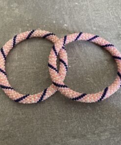 Nepal armbånd er en inspirerende og fascinerende smykkegenre, der vækker interessen hos smykkeentusiaster over hele verden. Disse håndlavede armbånd er kunstværker, der udstråler autenticitet, skønhed og dyb symbolik. Lad os dykke ned i den betagende verden af Nepal armbånd og udforske, hvad der gør dem så unikke og eftertragtede. Hvert Nepal armbånd er unikt, og det er netop denne individualitet, der appellerer til mange. Armbåndene er ofte skabt af dygtige nepalesiske håndværkere, der gennem generationer har forfinet deres teknikker til at skabe smykker af høj kvalitet. Disse håndværkere bruger traditionelle metoder, som har været en del af Nepals kultur og historie i århundreder. Processen er omhyggelig og kræver en stor grad af præcision og tålmodighed, hvilket gør hvert armbånd til en kærlighedsfyldt skabelse. Nepal armbånd er kendt for deres farverige og levende design. De er ofte dekoreret med perler, ædelstene, træ, metal eller andre naturlige materialer, hvilket giver dem et unikt udseende. Hvert enkelt element, der anvendes i armbåndene, er udvalgt omhyggeligt for at skabe en harmonisk kombination af farver og teksturer. Disse elementer er ofte inspireret af Nepals rige natur og kultur, hvilket giver armbåndene en autentisk følelse og en stærk forbindelse til landet. Symbolik spiller også en vigtig rolle i Nepal armbåndenes popularitet. Mange af armbåndene har indgraverede mønstre eller symboler, der repræsenterer vigtige aspekter af Nepals traditioner og spiritualitet. Disse symboler kan have betydning for held, lykke, kærlighed, beskyttelse eller en dybere forbindelse til naturen. At bære et Nepal armbånd kan derfor have en dybere betydning for bæreren og kan fungere som en påmindelse om deres forbindelse til Nepals rige arv. Nepal armbånd er ikke kun smukke smykker, men de har også en stærk social og kulturel betydning. Mange af disse smykker er håndlavede af kvinder, der er en del af samfundet i landområderne i Nepal. Produktionen af armbåndene giver disse kvinder mulighed for at skabe en bæredygtig indkomst, forbedre deres levevilkår og styrke deres selvstændighed. Når du køber et Nepal armbånd, bidrager du derfor til at støtte en positiv social indvirkning og bevare traditionelle håndværksmæssige metoder. Udover deres kulturelle og sociale betydning er Nepal armbånd også en favorit blandt modebevidste enkeltpersoner, der ønsker at tilføje en unik og autentisk touch til deres stil. Disse armbånd kan styles på utallige måder, uanset om du ønsker at skabe et bohemeinspireret look, en farverig festlig stil eller en subtil og elegant kombination. Der er et Nepal armbånd til enhver lejlighed og enhver personlig præference. I det store udvalg af smykker, der findes i dagens marked, skiller Nepal armbånd sig ud som en særlig perle. Deres håndlavede karakter, farverige design, dybe symbolik og sociale indvirkning gør dem til mere end bare smykker - de er en form for kunst og kultur, der fortæller historien om Nepal og dets folk. Ved at bære et Nepal armbånd, bærer du også med dig en del af dette rige og inspirerende land. Så uanset om du leder efter en meningsfuld gave eller ønsker at berige din egen smykkesamling, vil et Nepal armbånd være et mindeværdigt og værdsat valg.