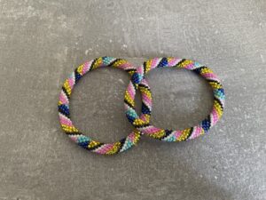 Nepal armbånd er en inspirerende og fascinerende smykkegenre, der vækker interessen hos smykkeentusiaster over hele verden. Disse håndlavede armbånd er kunstværker, der udstråler autenticitet, skønhed og dyb symbolik. Lad os dykke ned i den betagende verden af Nepal armbånd og udforske, hvad der gør dem så unikke og eftertragtede. Hvert Nepal armbånd er unikt, og det er netop denne individualitet, der appellerer til mange. Armbåndene er ofte skabt af dygtige nepalesiske håndværkere, der gennem generationer har forfinet deres teknikker til at skabe smykker af høj kvalitet. Disse håndværkere bruger traditionelle metoder, som har været en del af Nepals kultur og historie i århundreder. Processen er omhyggelig og kræver en stor grad af præcision og tålmodighed, hvilket gør hvert armbånd til en kærlighedsfyldt skabelse. Nepal armbånd er kendt for deres farverige og levende design. De er ofte dekoreret med perler, ædelstene, træ, metal eller andre naturlige materialer, hvilket giver dem et unikt udseende. Hvert enkelt element, der anvendes i armbåndene, er udvalgt omhyggeligt for at skabe en harmonisk kombination af farver og teksturer. Disse elementer er ofte inspireret af Nepals rige natur og kultur, hvilket giver armbåndene en autentisk følelse og en stærk forbindelse til landet. Symbolik spiller også en vigtig rolle i Nepal armbåndenes popularitet. Mange af armbåndene har indgraverede mønstre eller symboler, der repræsenterer vigtige aspekter af Nepals traditioner og spiritualitet. Disse symboler kan have betydning for held, lykke, kærlighed, beskyttelse eller en dybere forbindelse til naturen. At bære et Nepal armbånd kan derfor have en dybere betydning for bæreren og kan fungere som en påmindelse om deres forbindelse til Nepals rige arv. Nepal armbånd er ikke kun smukke smykker, men de har også en stærk social og kulturel betydning. Mange af disse smykker er håndlavede af kvinder, der er en del af samfundet i landområderne i Nepal. Produktionen af armbåndene giver disse kvinder mulighed for at skabe en bæredygtig indkomst, forbedre deres levevilkår og styrke deres selvstændighed. Når du køber et Nepal armbånd, bidrager du derfor til at støtte en positiv social indvirkning og bevare traditionelle håndværksmæssige metoder. Udover deres kulturelle og sociale betydning er Nepal armbånd også en favorit blandt modebevidste enkeltpersoner, der ønsker at tilføje en unik og autentisk touch til deres stil. Disse armbånd kan styles på utallige måder, uanset om du ønsker at skabe et bohemeinspireret look, en farverig festlig stil eller en subtil og elegant kombination. Der er et Nepal armbånd til enhver lejlighed og enhver personlig præference. I det store udvalg af smykker, der findes i dagens marked, skiller Nepal armbånd sig ud som en særlig perle. Deres håndlavede karakter, farverige design, dybe symbolik og sociale indvirkning gør dem til mere end bare smykker - de er en form for kunst og kultur, der fortæller historien om Nepal og dets folk. Ved at bære et Nepal armbånd, bærer du også med dig en del af dette rige og inspirerende land. Så uanset om du leder efter en meningsfuld gave eller ønsker at berige din egen smykkesamling, vil et Nepal armbånd være et mindeværdigt og værdsat valg.