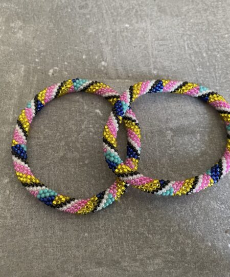 Nepal armbånd er en inspirerende og fascinerende smykkegenre, der vækker interessen hos smykkeentusiaster over hele verden. Disse håndlavede armbånd er kunstværker, der udstråler autenticitet, skønhed og dyb symbolik. Lad os dykke ned i den betagende verden af Nepal armbånd og udforske, hvad der gør dem så unikke og eftertragtede. Hvert Nepal armbånd er unikt, og det er netop denne individualitet, der appellerer til mange. Armbåndene er ofte skabt af dygtige nepalesiske håndværkere, der gennem generationer har forfinet deres teknikker til at skabe smykker af høj kvalitet. Disse håndværkere bruger traditionelle metoder, som har været en del af Nepals kultur og historie i århundreder. Processen er omhyggelig og kræver en stor grad af præcision og tålmodighed, hvilket gør hvert armbånd til en kærlighedsfyldt skabelse. Nepal armbånd er kendt for deres farverige og levende design. De er ofte dekoreret med perler, ædelstene, træ, metal eller andre naturlige materialer, hvilket giver dem et unikt udseende. Hvert enkelt element, der anvendes i armbåndene, er udvalgt omhyggeligt for at skabe en harmonisk kombination af farver og teksturer. Disse elementer er ofte inspireret af Nepals rige natur og kultur, hvilket giver armbåndene en autentisk følelse og en stærk forbindelse til landet. Symbolik spiller også en vigtig rolle i Nepal armbåndenes popularitet. Mange af armbåndene har indgraverede mønstre eller symboler, der repræsenterer vigtige aspekter af Nepals traditioner og spiritualitet. Disse symboler kan have betydning for held, lykke, kærlighed, beskyttelse eller en dybere forbindelse til naturen. At bære et Nepal armbånd kan derfor have en dybere betydning for bæreren og kan fungere som en påmindelse om deres forbindelse til Nepals rige arv. Nepal armbånd er ikke kun smukke smykker, men de har også en stærk social og kulturel betydning. Mange af disse smykker er håndlavede af kvinder, der er en del af samfundet i landområderne i Nepal. Produktionen af armbåndene giver disse kvinder mulighed for at skabe en bæredygtig indkomst, forbedre deres levevilkår og styrke deres selvstændighed. Når du køber et Nepal armbånd, bidrager du derfor til at støtte en positiv social indvirkning og bevare traditionelle håndværksmæssige metoder. Udover deres kulturelle og sociale betydning er Nepal armbånd også en favorit blandt modebevidste enkeltpersoner, der ønsker at tilføje en unik og autentisk touch til deres stil. Disse armbånd kan styles på utallige måder, uanset om du ønsker at skabe et bohemeinspireret look, en farverig festlig stil eller en subtil og elegant kombination. Der er et Nepal armbånd til enhver lejlighed og enhver personlig præference. I det store udvalg af smykker, der findes i dagens marked, skiller Nepal armbånd sig ud som en særlig perle. Deres håndlavede karakter, farverige design, dybe symbolik og sociale indvirkning gør dem til mere end bare smykker - de er en form for kunst og kultur, der fortæller historien om Nepal og dets folk. Ved at bære et Nepal armbånd, bærer du også med dig en del af dette rige og inspirerende land. Så uanset om du leder efter en meningsfuld gave eller ønsker at berige din egen smykkesamling, vil et Nepal armbånd være et mindeværdigt og værdsat valg.