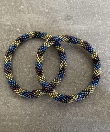 Nepal armbånd er en inspirerende og fascinerende smykkegenre, der vækker interessen hos smykkeentusiaster over hele verden. Disse håndlavede armbånd er kunstværker, der udstråler autenticitet, skønhed og dyb symbolik. Lad os dykke ned i den betagende verden af Nepal armbånd og udforske, hvad der gør dem så unikke og eftertragtede. Hvert Nepal armbånd er unikt, og det er netop denne individualitet, der appellerer til mange. Armbåndene er ofte skabt af dygtige nepalesiske håndværkere, der gennem generationer har forfinet deres teknikker til at skabe smykker af høj kvalitet. Disse håndværkere bruger traditionelle metoder, som har været en del af Nepals kultur og historie i århundreder. Processen er omhyggelig og kræver en stor grad af præcision og tålmodighed, hvilket gør hvert armbånd til en kærlighedsfyldt skabelse. Nepal armbånd er kendt for deres farverige og levende design. De er ofte dekoreret med perler, ædelstene, træ, metal eller andre naturlige materialer, hvilket giver dem et unikt udseende. Hvert enkelt element, der anvendes i armbåndene, er udvalgt omhyggeligt for at skabe en harmonisk kombination af farver og teksturer. Disse elementer er ofte inspireret af Nepals rige natur og kultur, hvilket giver armbåndene en autentisk følelse og en stærk forbindelse til landet. Symbolik spiller også en vigtig rolle i Nepal armbåndenes popularitet. Mange af armbåndene har indgraverede mønstre eller symboler, der repræsenterer vigtige aspekter af Nepals traditioner og spiritualitet. Disse symboler kan have betydning for held, lykke, kærlighed, beskyttelse eller en dybere forbindelse til naturen. At bære et Nepal armbånd kan derfor have en dybere betydning for bæreren og kan fungere som en påmindelse om deres forbindelse til Nepals rige arv. Nepal armbånd er ikke kun smukke smykker, men de har også en stærk social og kulturel betydning. Mange af disse smykker er håndlavede af kvinder, der er en del af samfundet i landområderne i Nepal. Produktionen af armbåndene giver disse kvinder mulighed for at skabe en bæredygtig indkomst, forbedre deres levevilkår og styrke deres selvstændighed. Når du køber et Nepal armbånd, bidrager du derfor til at støtte en positiv social indvirkning og bevare traditionelle håndværksmæssige metoder. Udover deres kulturelle og sociale betydning er Nepal armbånd også en favorit blandt modebevidste enkeltpersoner, der ønsker at tilføje en unik og autentisk touch til deres stil. Disse armbånd kan styles på utallige måder, uanset om du ønsker at skabe et bohemeinspireret look, en farverig festlig stil eller en subtil og elegant kombination. Der er et Nepal armbånd til enhver lejlighed og enhver personlig præference. I det store udvalg af smykker, der findes i dagens marked, skiller Nepal armbånd sig ud som en særlig perle. Deres håndlavede karakter, farverige design, dybe symbolik og sociale indvirkning gør dem til mere end bare smykker - de er en form for kunst og kultur, der fortæller historien om Nepal og dets folk. Ved at bære et Nepal armbånd, bærer du også med dig en del af dette rige og inspirerende land. Så uanset om du leder efter en meningsfuld gave eller ønsker at berige din egen smykkesamling, vil et Nepal armbånd være et mindeværdigt og værdsat valg.