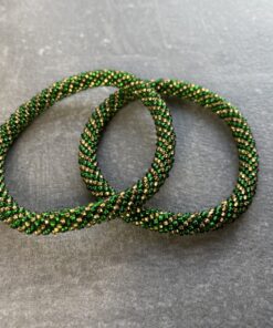 Unikke håndlavet nepal armbånd af glasperler- Som er knyttet perle for perle – Af Nepalesiske Kvinder.  Kvindegrupper i Nepal, Kathmandu Valley, udstyres med glasperler og bomuldsgarn, så de i deres fritid kan håndknytte de smukke perlearmbånd. Hvert armbånd er et unikt resultat af kvindernes håndarbejde og varierer i farvekombinationer og mønstre. De er hæklet med en bomuldssnor. Syntes man at de lidt stramme, kan man vride forsigtigt i dem så de bliver større. syntes man derimod at de er blive lidt for løse, kan man ligge dem i vand. dette gør at bomuldssnoren trækker sig sammen og de bliver mindre igen. Unikke håndlavet nepal armbånd, som er knyttet perle for perle, af nepalesiske kvinder. Vi har mere end 200 forskellige, at vælge i mellem. Så du kan finde de helt rigtige roll on nepal perle armbånd.