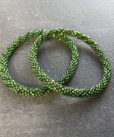 Unikke håndlavet nepal armbånd af glasperler- Som er knyttet perle for perle – Af Nepalesiske Kvinder.  Kvindegrupper i Nepal, Kathmandu Valley, udstyres med glasperler og bomuldsgarn, så de i deres fritid kan håndknytte de smukke perlearmbånd. Hvert armbånd er et unikt resultat af kvindernes håndarbejde og varierer i farvekombinationer og mønstre. De er hæklet med en bomuldssnor. Syntes man at de lidt stramme, kan man vride forsigtigt i dem så de bliver større. syntes man derimod at de er blive lidt for løse, kan man ligge dem i vand. dette gør at bomuldssnoren trækker sig sammen og de bliver mindre igen. Unikke håndlavet nepal armbånd, som er knyttet perle for perle, af nepalesiske kvinder. Vi har mere end 200 forskellige, at vælge i mellem. Så du kan finde de helt rigtige roll on nepal perle armbånd.