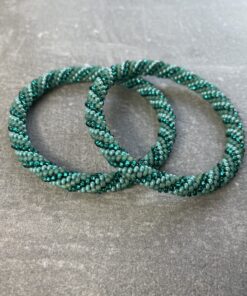 Unikke håndlavet nepal armbånd af glasperler- Som er knyttet perle for perle – Af Nepalesiske Kvinder.  Kvindegrupper i Nepal, Kathmandu Valley, udstyres med glasperler og bomuldsgarn, så de i deres fritid kan håndknytte de smukke perlearmbånd. Hvert armbånd er et unikt resultat af kvindernes håndarbejde og varierer i farvekombinationer og mønstre. De er hæklet med en bomuldssnor. Syntes man at de lidt stramme, kan man vride forsigtigt i dem så de bliver større. syntes man derimod at de er blive lidt for løse, kan man ligge dem i vand. dette gør at bomuldssnoren trækker sig sammen og de bliver mindre igen. Unikke håndlavet nepal armbånd, som er knyttet perle for perle, af nepalesiske kvinder. Vi har mere end 200 forskellige, at vælge i mellem. Så du kan finde de helt rigtige roll on nepal perle armbånd.