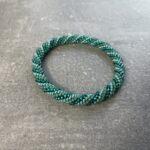 Unikke håndlavet nepal armbånd af glasperler- Som er knyttet perle for perle – Af Nepalesiske Kvinder.  Kvindegrupper i Nepal, Kathmandu Valley, udstyres med glasperler og bomuldsgarn, så de i deres fritid kan håndknytte de smukke perlearmbånd. Hvert armbånd er et unikt resultat af kvindernes håndarbejde og varierer i farvekombinationer og mønstre. De er hæklet med en bomuldssnor. Syntes man at de lidt stramme, kan man vride forsigtigt i dem så de bliver større. syntes man derimod at de er blive lidt for løse, kan man ligge dem i vand. dette gør at bomuldssnoren trækker sig sammen og de bliver mindre igen. Unikke håndlavet nepal armbånd, som er knyttet perle for perle, af nepalesiske kvinder. Vi har mere end 200 forskellige, at vælge i mellem. Så du kan finde de helt rigtige roll on nepal perle armbånd.