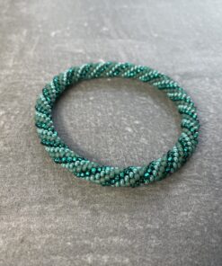 Unikke håndlavet nepal armbånd af glasperler- Som er knyttet perle for perle – Af Nepalesiske Kvinder. Kvindegrupper i Nepal, Kathmandu Valley, udstyres med glasperler og bomuldsgarn, så de i deres fritid kan håndknytte de smukke perlearmbånd. Hvert armbånd er et unikt resultat af kvindernes håndarbejde og varierer i farvekombinationer og mønstre. De er hæklet med en bomuldssnor. Syntes man at de lidt stramme, kan man vride forsigtigt i dem så de bliver større. syntes man derimod at de er blive lidt for løse, kan man ligge dem i vand. dette gør at bomuldssnoren trækker sig sammen og de bliver mindre igen. Unikke håndlavet nepal armbånd, som er knyttet perle for perle, af nepalesiske kvinder. Vi har mere end 200 forskellige, at vælge i mellem. Så du kan finde de helt rigtige roll on nepal perle armbånd.