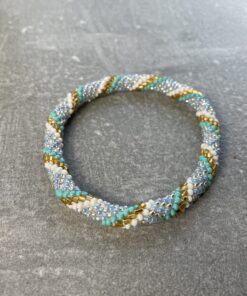 Unikke håndlavet nepal armbånd af glasperler- Som er knyttet perle for perle – Af Nepalesiske Kvinder.  Kvindegrupper i Nepal, Kathmandu Valley, udstyres med glasperler og bomuldsgarn, så de i deres fritid kan håndknytte de smukke perlearmbånd. Hvert armbånd er et unikt resultat af kvindernes håndarbejde og varierer i farvekombinationer og mønstre. De er hæklet med en bomuldssnor. Syntes man at de lidt stramme, kan man vride forsigtigt i dem så de bliver større. syntes man derimod at de er blive lidt for løse, kan man ligge dem i vand. dette gør at bomuldssnoren trækker sig sammen og de bliver mindre igen. Unikke håndlavet nepal armbånd, som er knyttet perle for perle, af nepalesiske kvinder. Vi har mere end 200 forskellige, at vælge i mellem. Så du kan finde de helt rigtige roll on nepal perle armbånd.