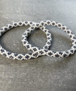 Unikke håndlavet nepal armbånd af glasperler- Som er knyttet perle for perle – Af Nepalesiske Kvinder.  Kvindegrupper i Nepal, Kathmandu Valley, udstyres med glasperler og bomuldsgarn, så de i deres fritid kan håndknytte de smukke perlearmbånd. Hvert armbånd er et unikt resultat af kvindernes håndarbejde og varierer i farvekombinationer og mønstre. De er hæklet med en bomuldssnor. Syntes man at de lidt stramme, kan man vride forsigtigt i dem så de bliver større. syntes man derimod at de er blive lidt for løse, kan man ligge dem i vand. dette gør at bomuldssnoren trækker sig sammen og de bliver mindre igen. Unikke håndlavet nepal armbånd, som er knyttet perle for perle, af nepalesiske kvinder. Vi har mere end 200 forskellige, at vælge i mellem. Så du kan finde de helt rigtige roll on nepal perle armbånd.