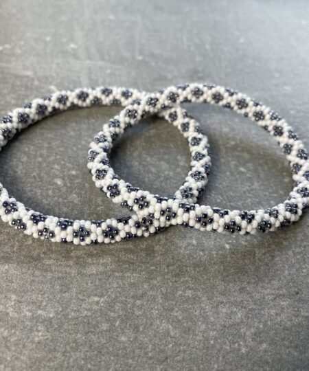 Unikke håndlavet nepal armbånd af glasperler- Som er knyttet perle for perle – Af Nepalesiske Kvinder.  Kvindegrupper i Nepal, Kathmandu Valley, udstyres med glasperler og bomuldsgarn, så de i deres fritid kan håndknytte de smukke perlearmbånd. Hvert armbånd er et unikt resultat af kvindernes håndarbejde og varierer i farvekombinationer og mønstre. De er hæklet med en bomuldssnor. Syntes man at de lidt stramme, kan man vride forsigtigt i dem så de bliver større. syntes man derimod at de er blive lidt for løse, kan man ligge dem i vand. dette gør at bomuldssnoren trækker sig sammen og de bliver mindre igen. Unikke håndlavet nepal armbånd, som er knyttet perle for perle, af nepalesiske kvinder. Vi har mere end 200 forskellige, at vælge i mellem. Så du kan finde de helt rigtige roll on nepal perle armbånd.