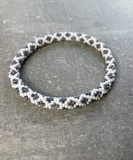 Unikke håndlavet nepal armbånd af glasperler- Som er knyttet perle for perle – Af Nepalesiske Kvinder.  Kvindegrupper i Nepal, Kathmandu Valley, udstyres med glasperler og bomuldsgarn, så de i deres fritid kan håndknytte de smukke perlearmbånd. Hvert armbånd er et unikt resultat af kvindernes håndarbejde og varierer i farvekombinationer og mønstre. De er hæklet med en bomuldssnor. Syntes man at de lidt stramme, kan man vride forsigtigt i dem så de bliver større. syntes man derimod at de er blive lidt for løse, kan man ligge dem i vand. dette gør at bomuldssnoren trækker sig sammen og de bliver mindre igen. Unikke håndlavet nepal armbånd, som er knyttet perle for perle, af nepalesiske kvinder. Vi har mere end 200 forskellige, at vælge i mellem. Så du kan finde de helt rigtige roll on nepal perle armbånd.