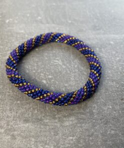 Unikke håndlavet nepal armbånd af glasperler- Som er knyttet perle for perle – Af Nepalesiske Kvinder.  Kvindegrupper i Nepal, Kathmandu Valley, udstyres med glasperler og bomuldsgarn, så de i deres fritid kan håndknytte de smukke perlearmbånd. Hvert armbånd er et unikt resultat af kvindernes håndarbejde og varierer i farvekombinationer og mønstre. De er hæklet med en bomuldssnor. Syntes man at de lidt stramme, kan man vride forsigtigt i dem så de bliver større. syntes man derimod at de er blive lidt for løse, kan man ligge dem i vand. dette gør at bomuldssnoren trækker sig sammen og de bliver mindre igen. Unikke håndlavet nepal armbånd, som er knyttet perle for perle, af nepalesiske kvinder. Vi har mere end 200 forskellige, at vælge i mellem. Så du kan finde de helt rigtige roll on nepal perle armbånd.