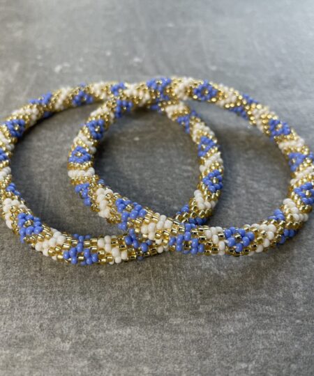 Unikke håndlavet nepal armbånd af glasperler- Som er knyttet perle for perle – Af Nepalesiske Kvinder. Kvindegrupper i Nepal, Kathmandu Valley, udstyres med glasperler og bomuldsgarn, så de i deres fritid kan håndknytte de smukke perlearmbånd. Hvert armbånd er et unikt resultat af kvindernes håndarbejde og varierer i farvekombinationer og mønstre. De er hæklet med en bomuldssnor. Syntes man at de lidt stramme, kan man vride forsigtigt i dem så de bliver større. syntes man derimod at de er blive lidt for løse, kan man ligge dem i vand. dette gør at bomuldssnoren trækker sig sammen og de bliver mindre igen. Unikke håndlavet nepal armbånd, som er knyttet perle for perle, af nepalesiske kvinder. Vi har mere end 200 forskellige, at vælge i mellem. Så du kan finde de helt rigtige roll on nepal perle armbånd.