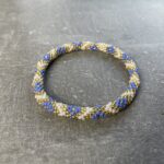 Unikke håndlavet nepal armbånd af glasperler- Som er knyttet perle for perle – Af Nepalesiske Kvinder.  Kvindegrupper i Nepal, Kathmandu Valley, udstyres med glasperler og bomuldsgarn, så de i deres fritid kan håndknytte de smukke perlearmbånd. Hvert armbånd er et unikt resultat af kvindernes håndarbejde og varierer i farvekombinationer og mønstre. De er hæklet med en bomuldssnor. Syntes man at de lidt stramme, kan man vride forsigtigt i dem så de bliver større. syntes man derimod at de er blive lidt for løse, kan man ligge dem i vand. dette gør at bomuldssnoren trækker sig sammen og de bliver mindre igen. Unikke håndlavet nepal armbånd, som er knyttet perle for perle, af nepalesiske kvinder. Vi har mere end 200 forskellige, at vælge i mellem. Så du kan finde de helt rigtige roll on nepal perle armbånd.