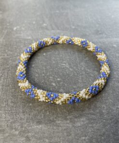 Unikke håndlavet nepal armbånd af glasperler- Som er knyttet perle for perle – Af Nepalesiske Kvinder.  Kvindegrupper i Nepal, Kathmandu Valley, udstyres med glasperler og bomuldsgarn, så de i deres fritid kan håndknytte de smukke perlearmbånd. Hvert armbånd er et unikt resultat af kvindernes håndarbejde og varierer i farvekombinationer og mønstre. De er hæklet med en bomuldssnor. Syntes man at de lidt stramme, kan man vride forsigtigt i dem så de bliver større. syntes man derimod at de er blive lidt for løse, kan man ligge dem i vand. dette gør at bomuldssnoren trækker sig sammen og de bliver mindre igen. Unikke håndlavet nepal armbånd, som er knyttet perle for perle, af nepalesiske kvinder. Vi har mere end 200 forskellige, at vælge i mellem. Så du kan finde de helt rigtige roll on nepal perle armbånd.