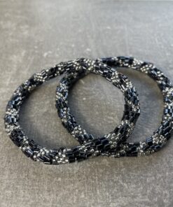 Unikke håndlavet nepal armbånd af glasperler- Som er knyttet perle for perle – Af Nepalesiske Kvinder.  Kvindegrupper i Nepal, Kathmandu Valley, udstyres med glasperler og bomuldsgarn, så de i deres fritid kan håndknytte de smukke perlearmbånd. Hvert armbånd er et unikt resultat af kvindernes håndarbejde og varierer i farvekombinationer og mønstre. De er hæklet med en bomuldssnor. Syntes man at de lidt stramme, kan man vride forsigtigt i dem så de bliver større. syntes man derimod at de er blive lidt for løse, kan man ligge dem i vand. dette gør at bomuldssnoren trækker sig sammen og de bliver mindre igen. Unikke håndlavet nepal armbånd, som er knyttet perle for perle, af nepalesiske kvinder. Vi har mere end 200 forskellige, at vælge i mellem. Så du kan finde de helt rigtige roll on nepal perle armbånd.