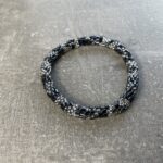 Unikke håndlavet nepal armbånd af glasperler- Som er knyttet perle for perle – Af Nepalesiske Kvinder.  Kvindegrupper i Nepal, Kathmandu Valley, udstyres med glasperler og bomuldsgarn, så de i deres fritid kan håndknytte de smukke perlearmbånd. Hvert armbånd er et unikt resultat af kvindernes håndarbejde og varierer i farvekombinationer og mønstre. De er hæklet med en bomuldssnor. Syntes man at de lidt stramme, kan man vride forsigtigt i dem så de bliver større. syntes man derimod at de er blive lidt for løse, kan man ligge dem i vand. dette gør at bomuldssnoren trækker sig sammen og de bliver mindre igen. Unikke håndlavet nepal armbånd, som er knyttet perle for perle, af nepalesiske kvinder. Vi har mere end 200 forskellige, at vælge i mellem. Så du kan finde de helt rigtige roll on nepal perle armbånd.