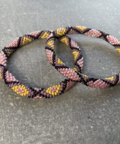 Unikke håndlavet nepal armbånd af glasperler- Som er knyttet perle for perle – Af Nepalesiske Kvinder.  Kvindegrupper i Nepal, Kathmandu Valley, udstyres med glasperler og bomuldsgarn, så de i deres fritid kan håndknytte de smukke perlearmbånd. Hvert armbånd er et unikt resultat af kvindernes håndarbejde og varierer i farvekombinationer og mønstre. De er hæklet med en bomuldssnor. Syntes man at de lidt stramme, kan man vride forsigtigt i dem så de bliver større. syntes man derimod at de er blive lidt for løse, kan man ligge dem i vand. dette gør at bomuldssnoren trækker sig sammen og de bliver mindre igen. Unikke håndlavet nepal armbånd, som er knyttet perle for perle, af nepalesiske kvinder. Vi har mere end 200 forskellige, at vælge i mellem. Så du kan finde de helt rigtige roll on nepal perle armbånd.