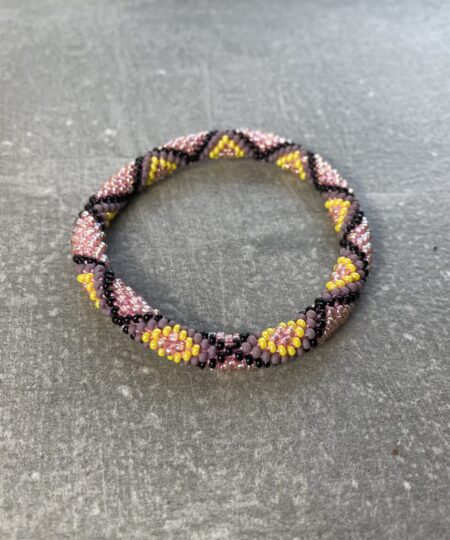 Unikke håndlavet nepal armbånd af glasperler- Som er knyttet perle for perle – Af Nepalesiske Kvinder.  Kvindegrupper i Nepal, Kathmandu Valley, udstyres med glasperler og bomuldsgarn, så de i deres fritid kan håndknytte de smukke perlearmbånd. Hvert armbånd er et unikt resultat af kvindernes håndarbejde og varierer i farvekombinationer og mønstre. De er hæklet med en bomuldssnor. Syntes man at de lidt stramme, kan man vride forsigtigt i dem så de bliver større. syntes man derimod at de er blive lidt for løse, kan man ligge dem i vand. dette gør at bomuldssnoren trækker sig sammen og de bliver mindre igen. Unikke håndlavet nepal armbånd, som er knyttet perle for perle, af nepalesiske kvinder. Vi har mere end 200 forskellige, at vælge i mellem. Så du kan finde de helt rigtige roll on nepal perle armbånd.