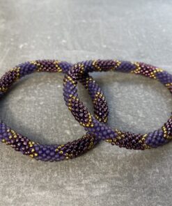 Unikke håndlavet nepal armbånd af glasperler- Som er knyttet perle for perle – Af Nepalesiske Kvinder.  Kvindegrupper i Nepal, Kathmandu Valley, udstyres med glasperler og bomuldsgarn, så de i deres fritid kan håndknytte de smukke perlearmbånd. Hvert armbånd er et unikt resultat af kvindernes håndarbejde og varierer i farvekombinationer og mønstre. De er hæklet med en bomuldssnor. Syntes man at de lidt stramme, kan man vride forsigtigt i dem så de bliver større. syntes man derimod at de er blive lidt for løse, kan man ligge dem i vand. dette gør at bomuldssnoren trækker sig sammen og de bliver mindre igen. Unikke håndlavet nepal armbånd, som er knyttet perle for perle, af nepalesiske kvinder. Vi har mere end 200 forskellige, at vælge i mellem. Så du kan finde de helt rigtige roll on nepal perle armbånd.