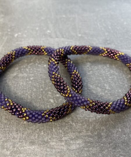 Unikke håndlavet nepal armbånd af glasperler- Som er knyttet perle for perle – Af Nepalesiske Kvinder.  Kvindegrupper i Nepal, Kathmandu Valley, udstyres med glasperler og bomuldsgarn, så de i deres fritid kan håndknytte de smukke perlearmbånd. Hvert armbånd er et unikt resultat af kvindernes håndarbejde og varierer i farvekombinationer og mønstre. De er hæklet med en bomuldssnor. Syntes man at de lidt stramme, kan man vride forsigtigt i dem så de bliver større. syntes man derimod at de er blive lidt for løse, kan man ligge dem i vand. dette gør at bomuldssnoren trækker sig sammen og de bliver mindre igen. Unikke håndlavet nepal armbånd, som er knyttet perle for perle, af nepalesiske kvinder. Vi har mere end 200 forskellige, at vælge i mellem. Så du kan finde de helt rigtige roll on nepal perle armbånd.