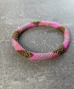 Unikke håndlavet nepal armbånd af glasperler- Som er knyttet perle for perle – Af Nepalesiske Kvinder.  Kvindegrupper i Nepal, Kathmandu Valley, udstyres med glasperler og bomuldsgarn, så de i deres fritid kan håndknytte de smukke perlearmbånd. Hvert armbånd er et unikt resultat af kvindernes håndarbejde og varierer i farvekombinationer og mønstre. De er hæklet med en bomuldssnor. Syntes man at de lidt stramme, kan man vride forsigtigt i dem så de bliver større. syntes man derimod at de er blive lidt for løse, kan man ligge dem i vand. dette gør at bomuldssnoren trækker sig sammen og de bliver mindre igen. Unikke håndlavet nepal armbånd, som er knyttet perle for perle, af nepalesiske kvinder. Vi har mere end 200 forskellige, at vælge i mellem. Så du kan finde de helt rigtige roll on nepal perle armbånd.