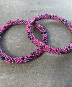 Unikke håndlavet nepal armbånd af glasperler- Som er knyttet perle for perle – Af Nepalesiske Kvinder.  Kvindegrupper i Nepal, Kathmandu Valley, udstyres med glasperler og bomuldsgarn, så de i deres fritid kan håndknytte de smukke perlearmbånd. Hvert armbånd er et unikt resultat af kvindernes håndarbejde og varierer i farvekombinationer og mønstre. De er hæklet med en bomuldssnor. Syntes man at de lidt stramme, kan man vride forsigtigt i dem så de bliver større. syntes man derimod at de er blive lidt for løse, kan man ligge dem i vand. dette gør at bomuldssnoren trækker sig sammen og de bliver mindre igen. Unikke håndlavet nepal armbånd, som er knyttet perle for perle, af nepalesiske kvinder. Vi har mere end 200 forskellige, at vælge i mellem. Så du kan finde de helt rigtige roll on nepal perle armbånd.