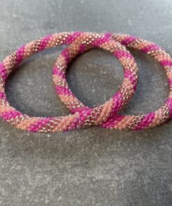 Unikke håndlavet nepal armbånd af glasperler- Som er knyttet perle for perle – Af Nepalesiske Kvinder.  Kvindegrupper i Nepal, Kathmandu Valley, udstyres med glasperler og bomuldsgarn, så de i deres fritid kan håndknytte de smukke perlearmbånd. Hvert armbånd er et unikt resultat af kvindernes håndarbejde og varierer i farvekombinationer og mønstre. De er hæklet med en bomuldssnor. Syntes man at de lidt stramme, kan man vride forsigtigt i dem så de bliver større. syntes man derimod at de er blive lidt for løse, kan man ligge dem i vand. dette gør at bomuldssnoren trækker sig sammen og de bliver mindre igen. Unikke håndlavet nepal armbånd, som er knyttet perle for perle, af nepalesiske kvinder. Vi har mere end 200 forskellige, at vælge i mellem. Så du kan finde de helt rigtige roll on nepal perle armbånd.