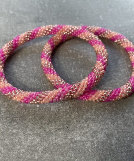 Unikke håndlavet nepal armbånd af glasperler- Som er knyttet perle for perle – Af Nepalesiske Kvinder.  Kvindegrupper i Nepal, Kathmandu Valley, udstyres med glasperler og bomuldsgarn, så de i deres fritid kan håndknytte de smukke perlearmbånd. Hvert armbånd er et unikt resultat af kvindernes håndarbejde og varierer i farvekombinationer og mønstre. De er hæklet med en bomuldssnor. Syntes man at de lidt stramme, kan man vride forsigtigt i dem så de bliver større. syntes man derimod at de er blive lidt for løse, kan man ligge dem i vand. dette gør at bomuldssnoren trækker sig sammen og de bliver mindre igen. Unikke håndlavet nepal armbånd, som er knyttet perle for perle, af nepalesiske kvinder. Vi har mere end 200 forskellige, at vælge i mellem. Så du kan finde de helt rigtige roll on nepal perle armbånd.