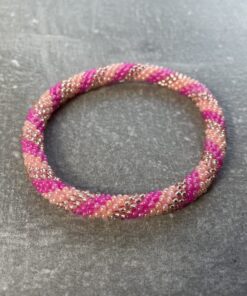 Unikke håndlavet nepal armbånd af glasperler- Som er knyttet perle for perle – Af Nepalesiske Kvinder.  Kvindegrupper i Nepal, Kathmandu Valley, udstyres med glasperler og bomuldsgarn, så de i deres fritid kan håndknytte de smukke perlearmbånd. Hvert armbånd er et unikt resultat af kvindernes håndarbejde og varierer i farvekombinationer og mønstre. De er hæklet med en bomuldssnor. Syntes man at de lidt stramme, kan man vride forsigtigt i dem så de bliver større. syntes man derimod at de er blive lidt for løse, kan man ligge dem i vand. dette gør at bomuldssnoren trækker sig sammen og de bliver mindre igen. Unikke håndlavet nepal armbånd, som er knyttet perle for perle, af nepalesiske kvinder. Vi har mere end 200 forskellige, at vælge i mellem. Så du kan finde de helt rigtige roll on nepal perle armbånd.