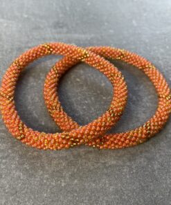 Unikke håndlavet nepal armbånd af glasperler- Som er knyttet perle for perle – Af Nepalesiske Kvinder. Kvindegrupper i Nepal, Kathmandu Valley, udstyres med glasperler og bomuldsgarn, så de i deres fritid kan håndknytte de smukke perlearmbånd. Hvert armbånd er et unikt resultat af kvindernes håndarbejde og varierer i farvekombinationer og mønstre. De er hæklet med en bomuldssnor. Syntes man at de lidt stramme, kan man vride forsigtigt i dem så de bliver større. syntes man derimod at de er blive lidt for løse, kan man ligge dem i vand. dette gør at bomuldssnoren trækker sig sammen og de bliver mindre igen. Unikke håndlavet nepal armbånd, som er knyttet perle for perle, af nepalesiske kvinder. Vi har mere end 200 forskellige, at vælge i mellem. Så du kan finde de helt rigtige roll on nepal perle armbånd.